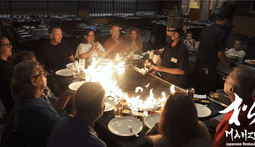 Large group around a hibachi table as the chef lights a flame at Mahzu East Windsor