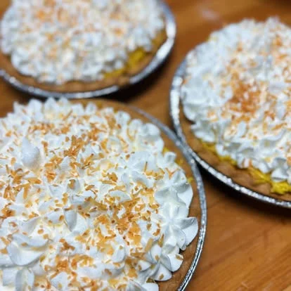 Coconut cream pie topped with whipped cream and toasted coconut