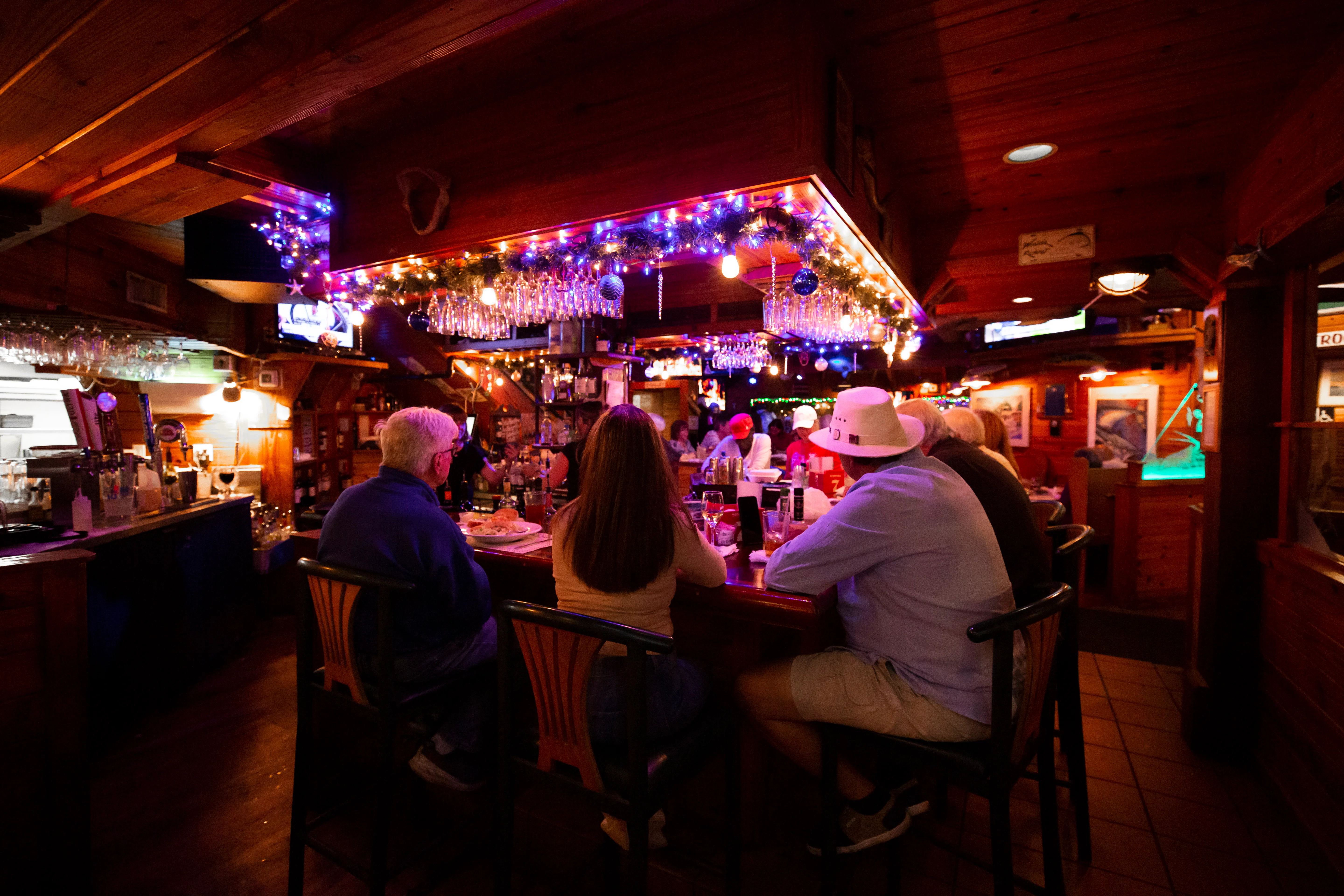 Cozy bar interior with festive lighting and patrons enjoying drinks