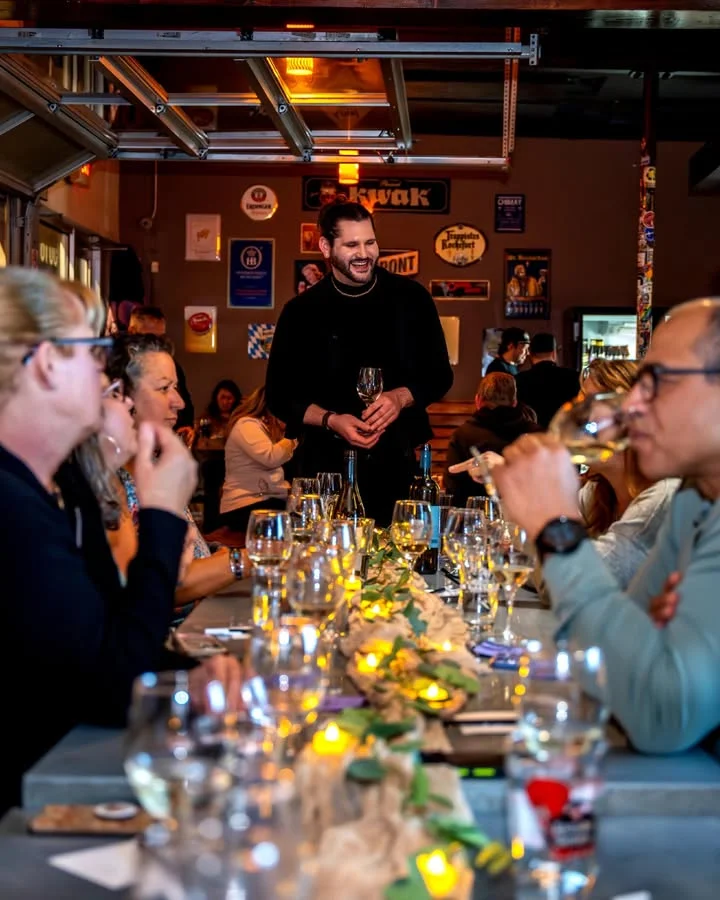Engaging dining experience with guests enjoying wine at a restaurant table.