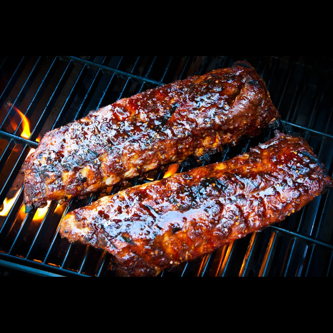 Smoky barbecue ribs glazed with sauce on a grill