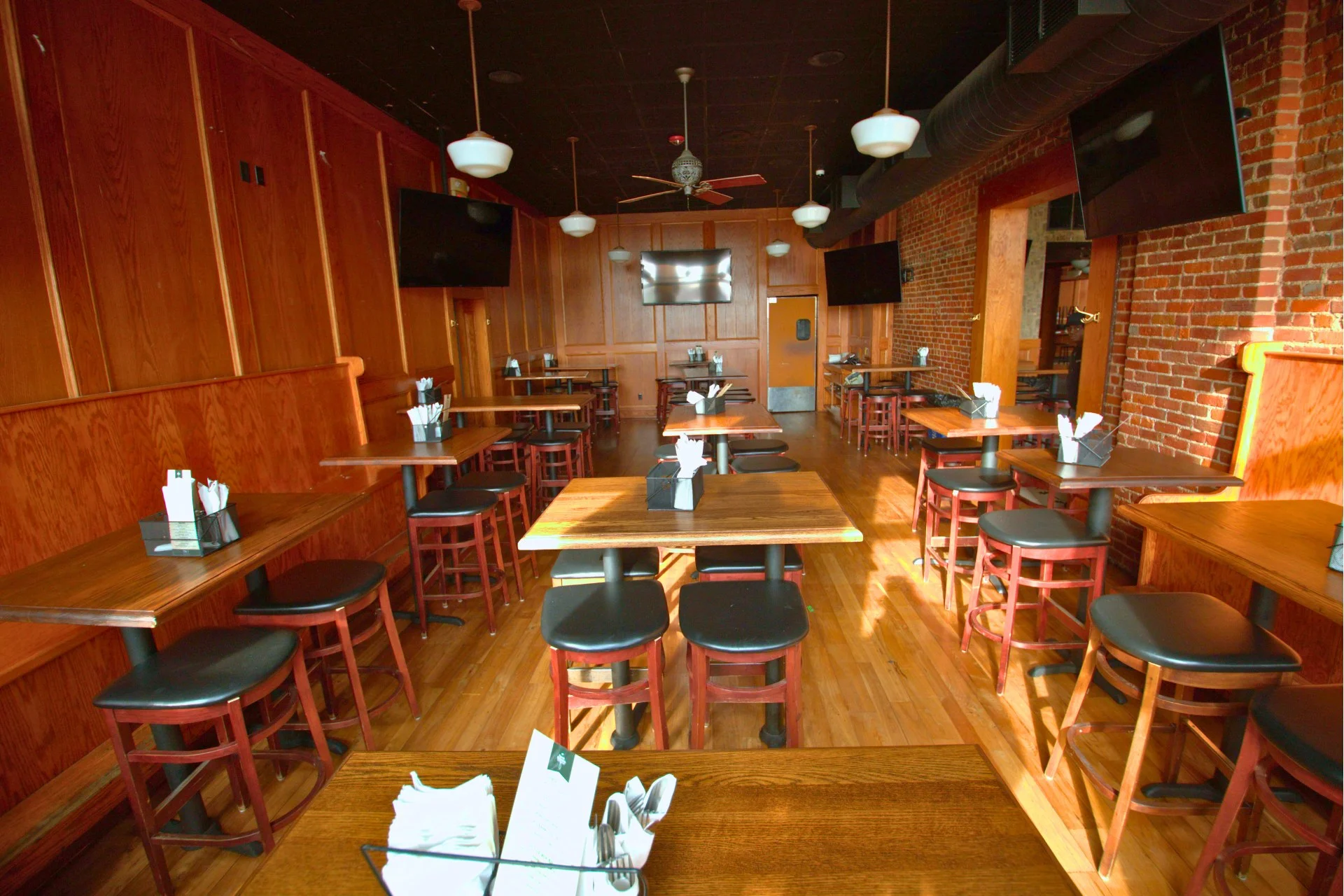 Restaurant area with wood panelling and exposed brick walls
