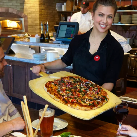 Server holding pizza 
