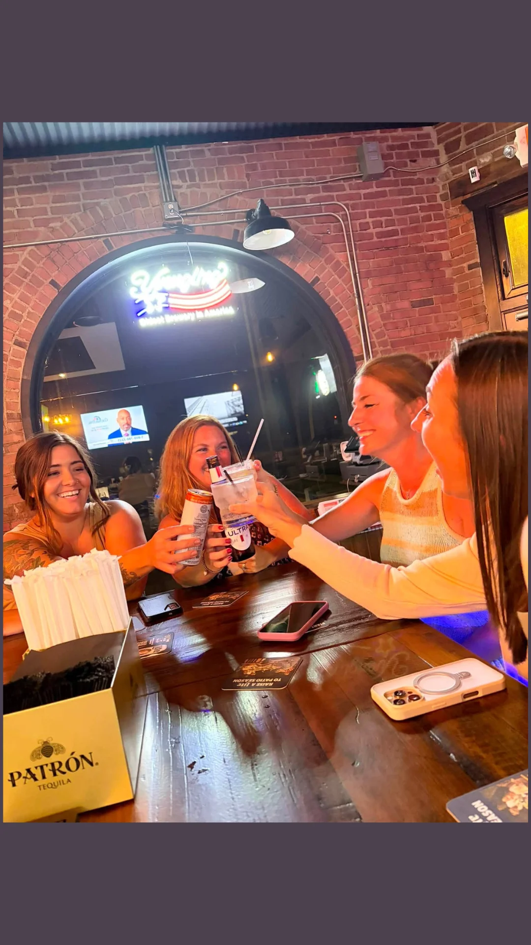 Friends toasting drinks at a lively bar with rustic decor