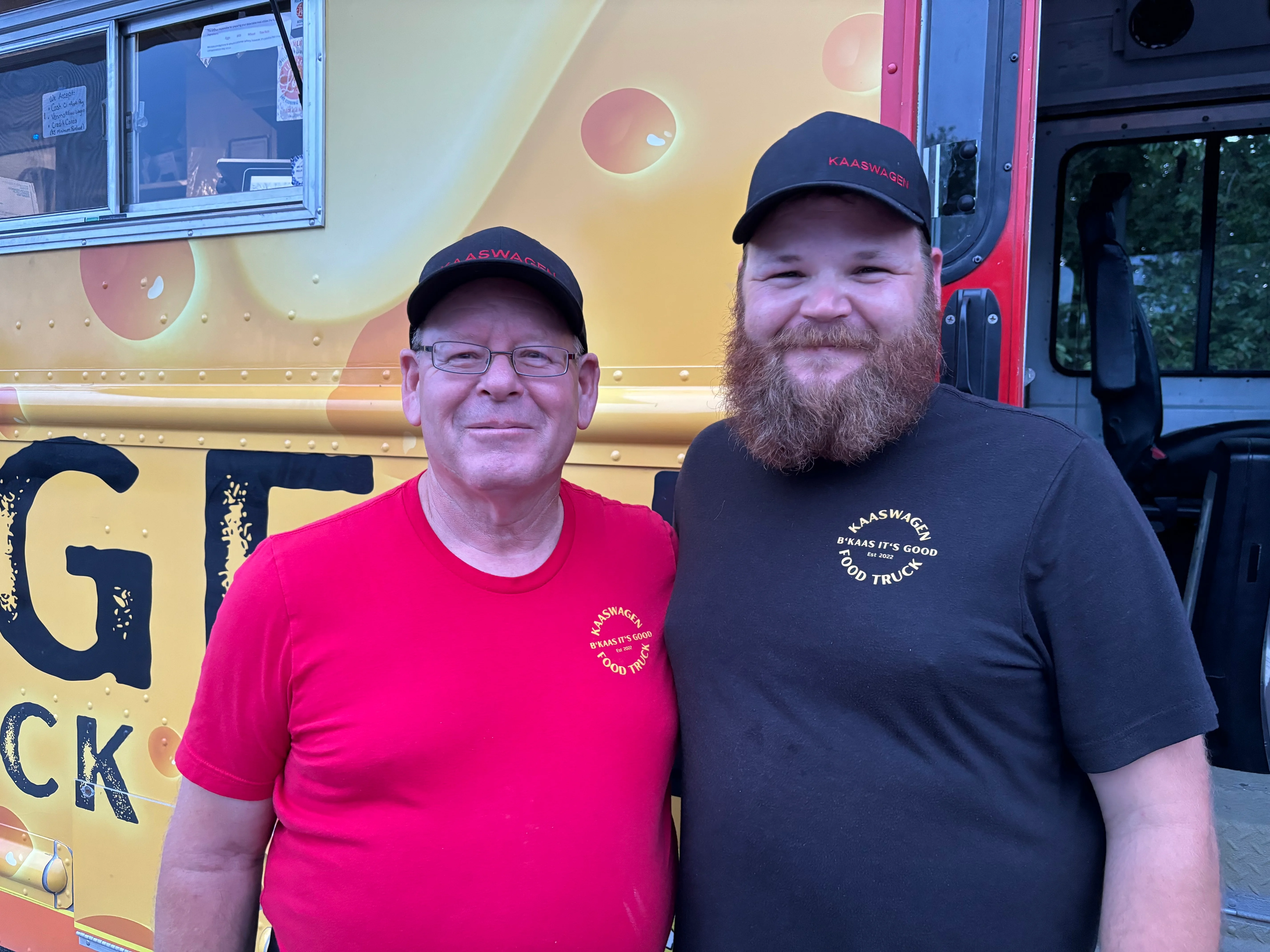 Two smiling chefs in front of a food truck