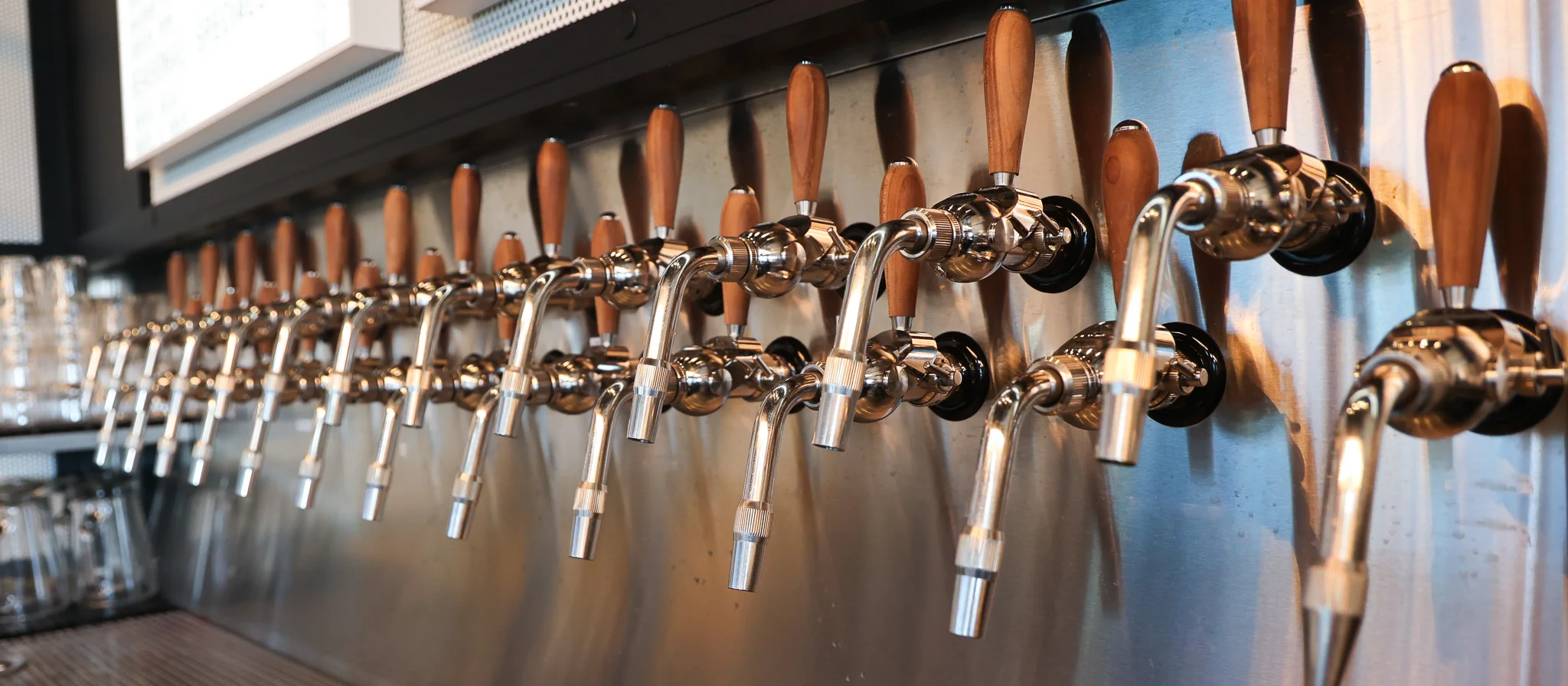 Modern bar with multiple beer taps and wooden handles