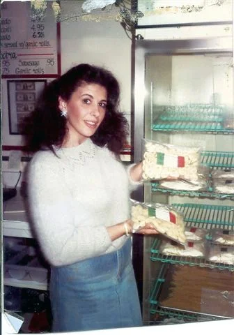 Woman showcasing Italian pasta in a restaurant