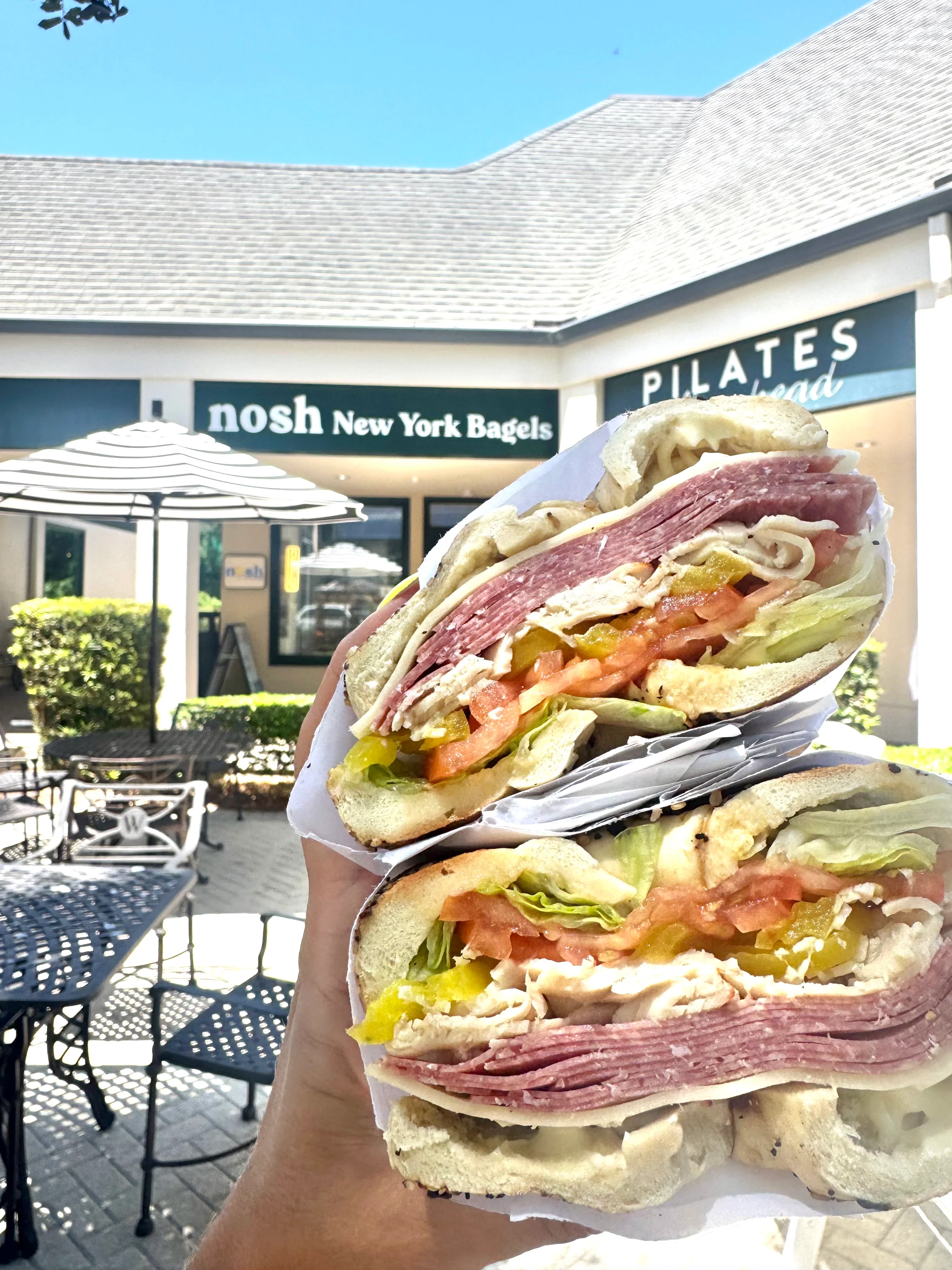 nosh NY bagels owners celebrating the Hilton Head Island grand opening with a cake.