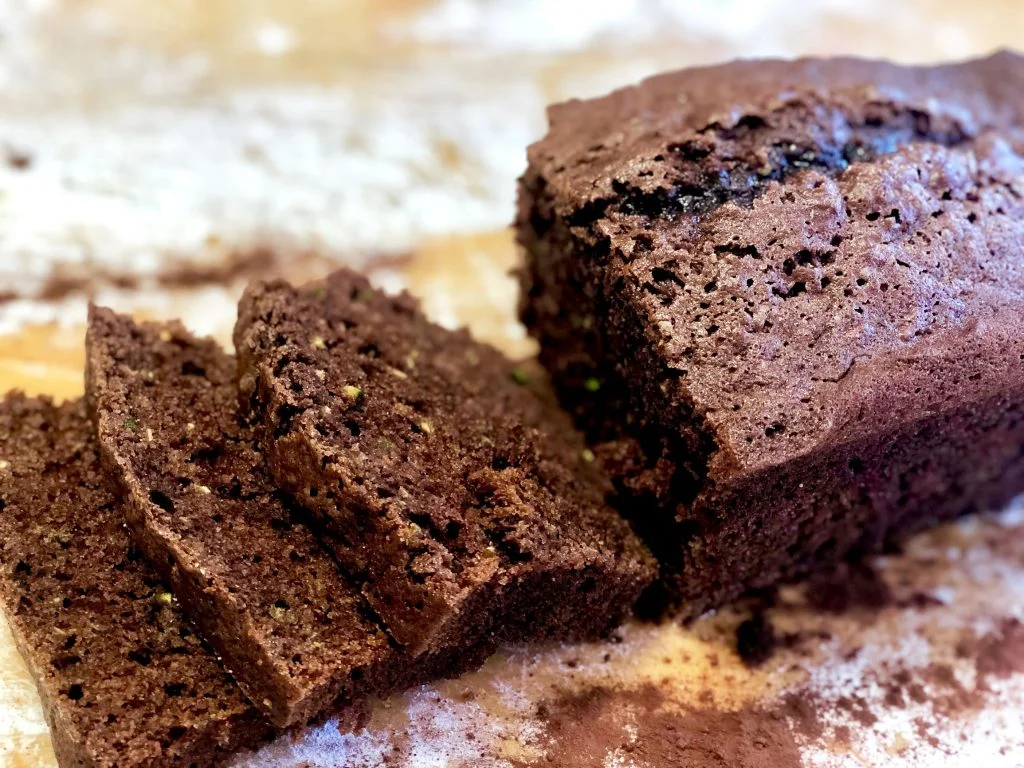 Moist chocolate zucchini bread sliced on a wooden board