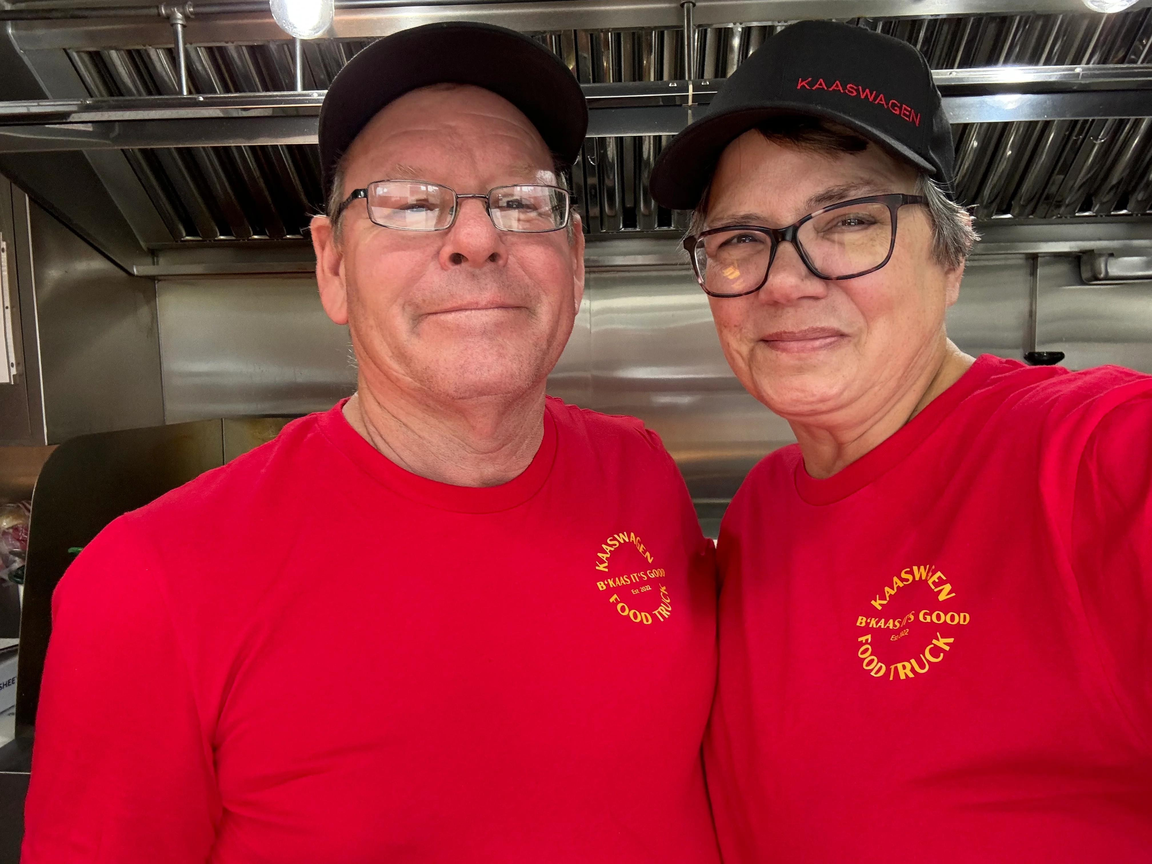 Food truck owners smiling in their vibrant red shirts