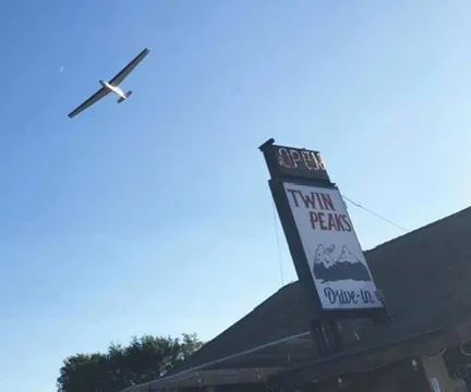 Twin Peaks restaurant sign with a plane flying overhead