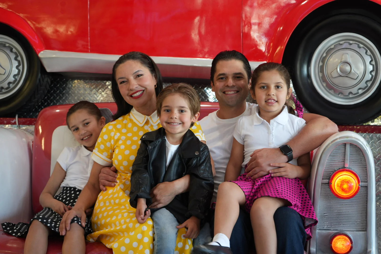 Family portrait in a retro diner setting with vibrant decor