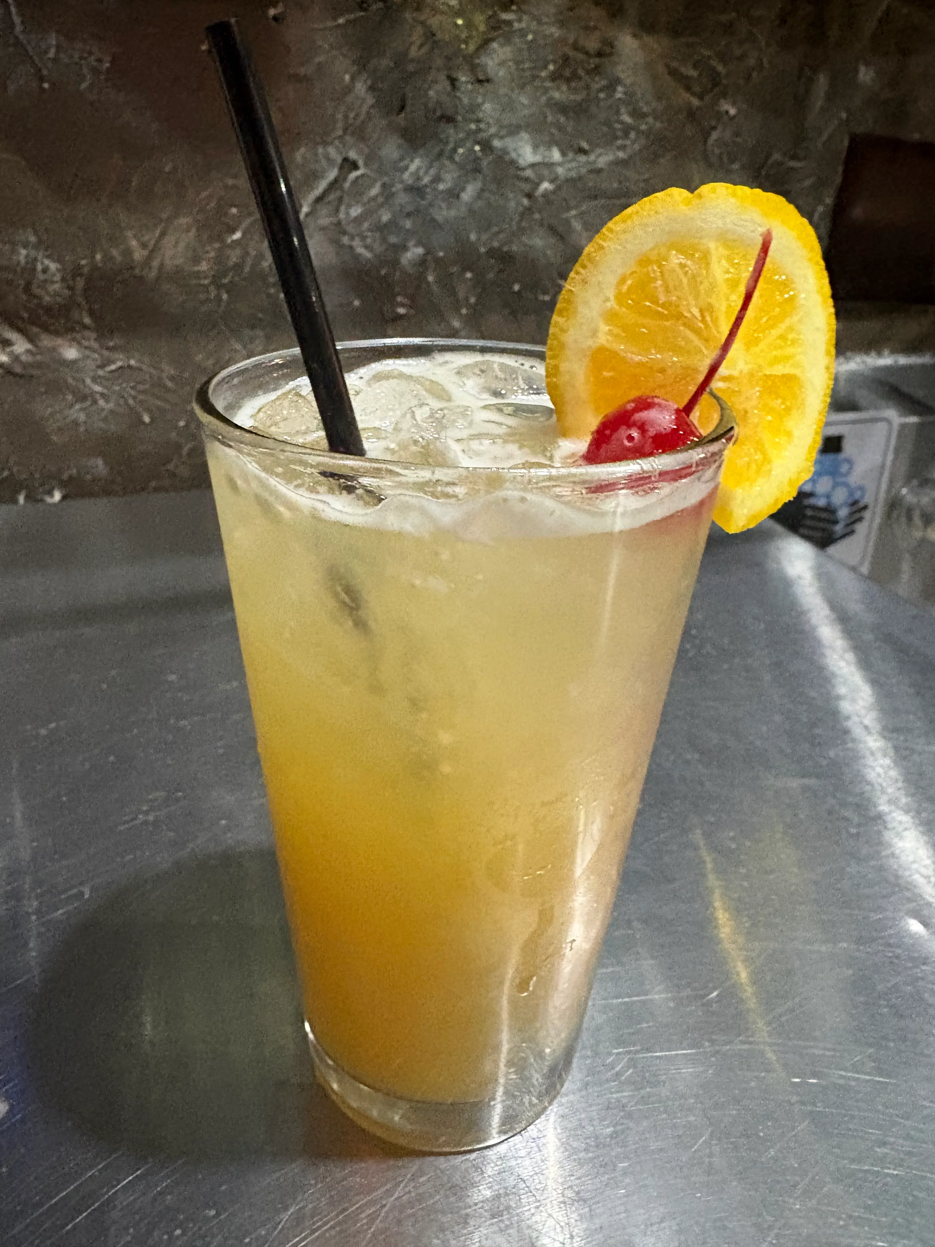 Refreshing tropical cocktail with orange and cherry garnish