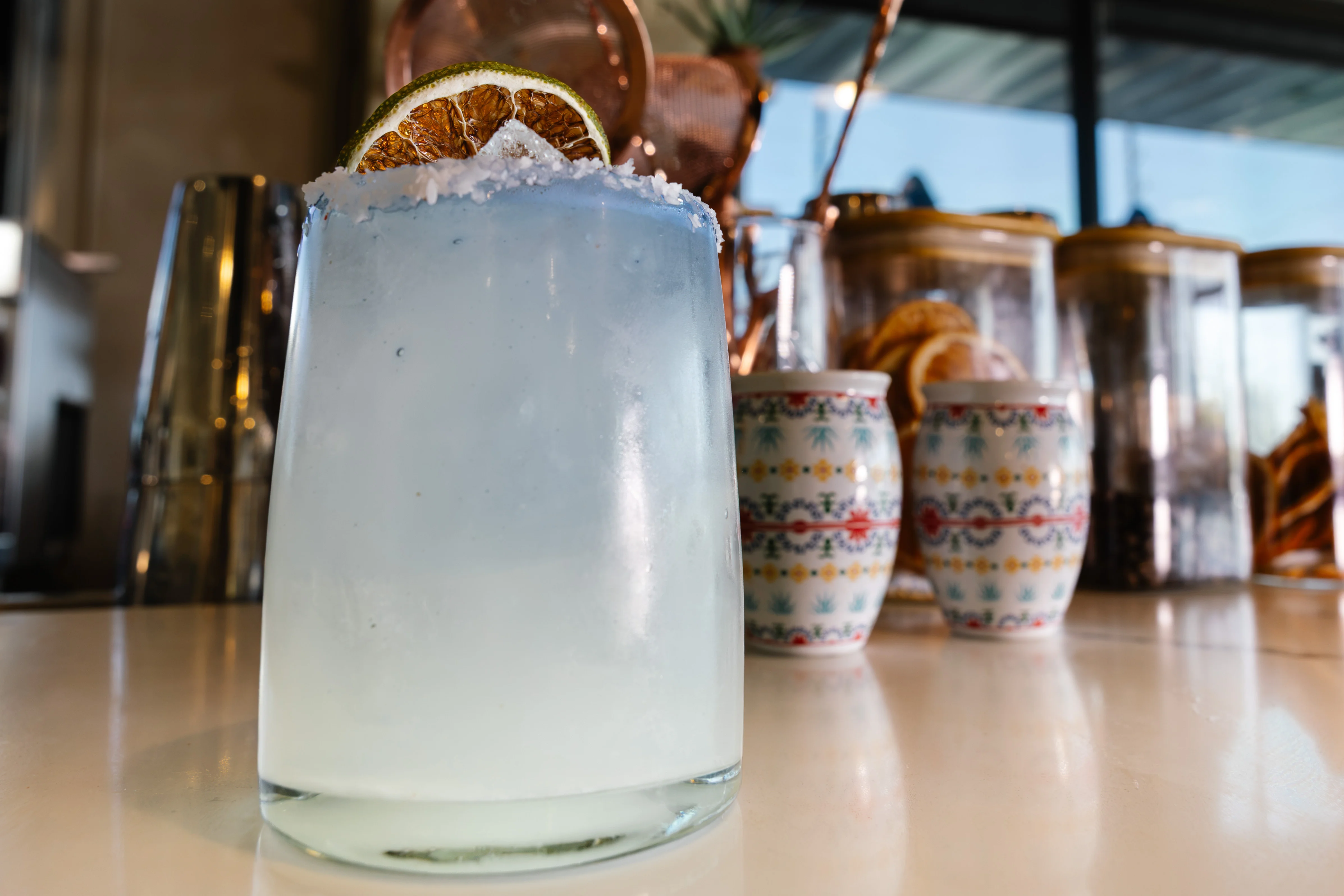 Refreshing blue cocktail garnished with dried lime slice