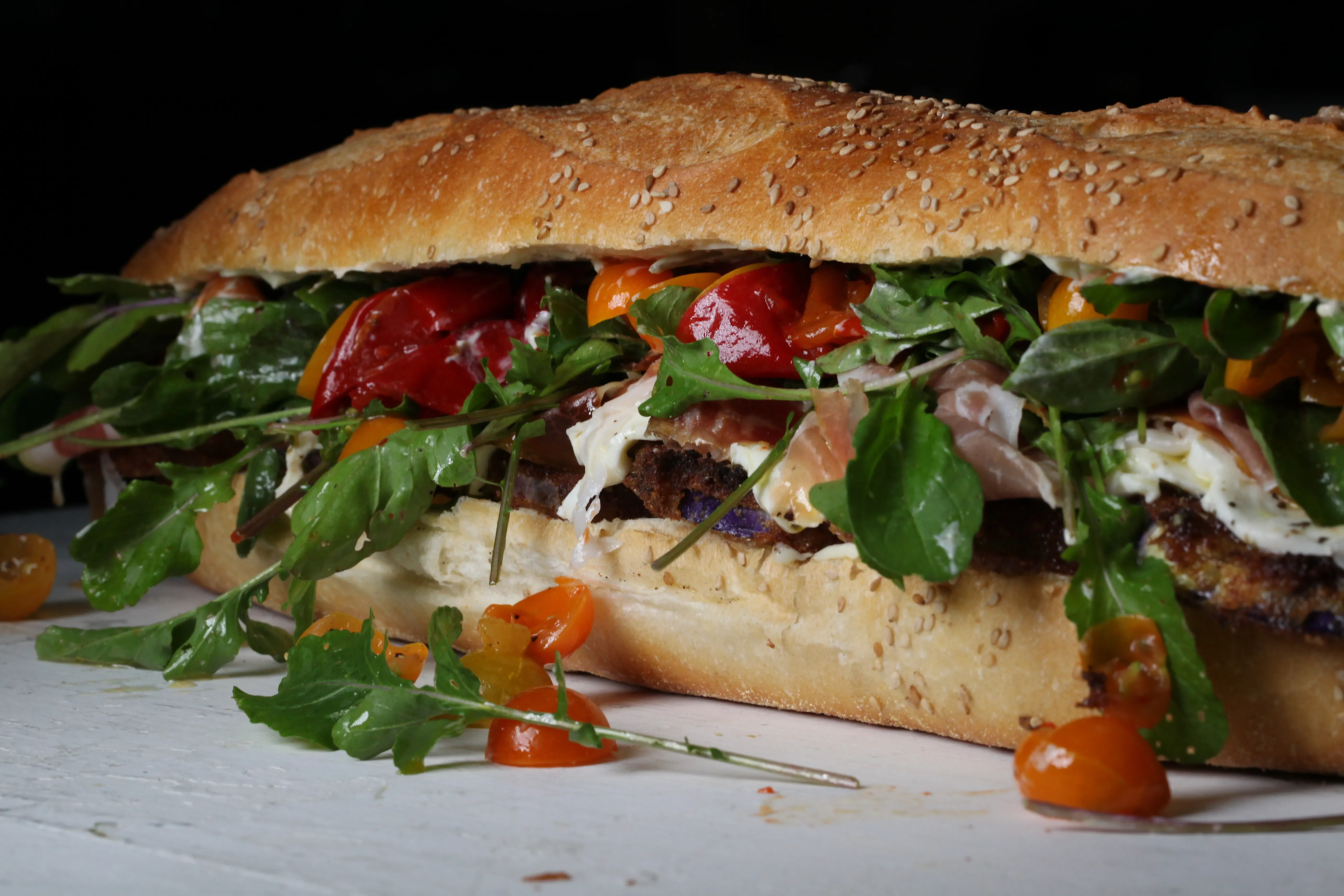 Italian sub sandwich loaded with fresh greens and roasted peppers