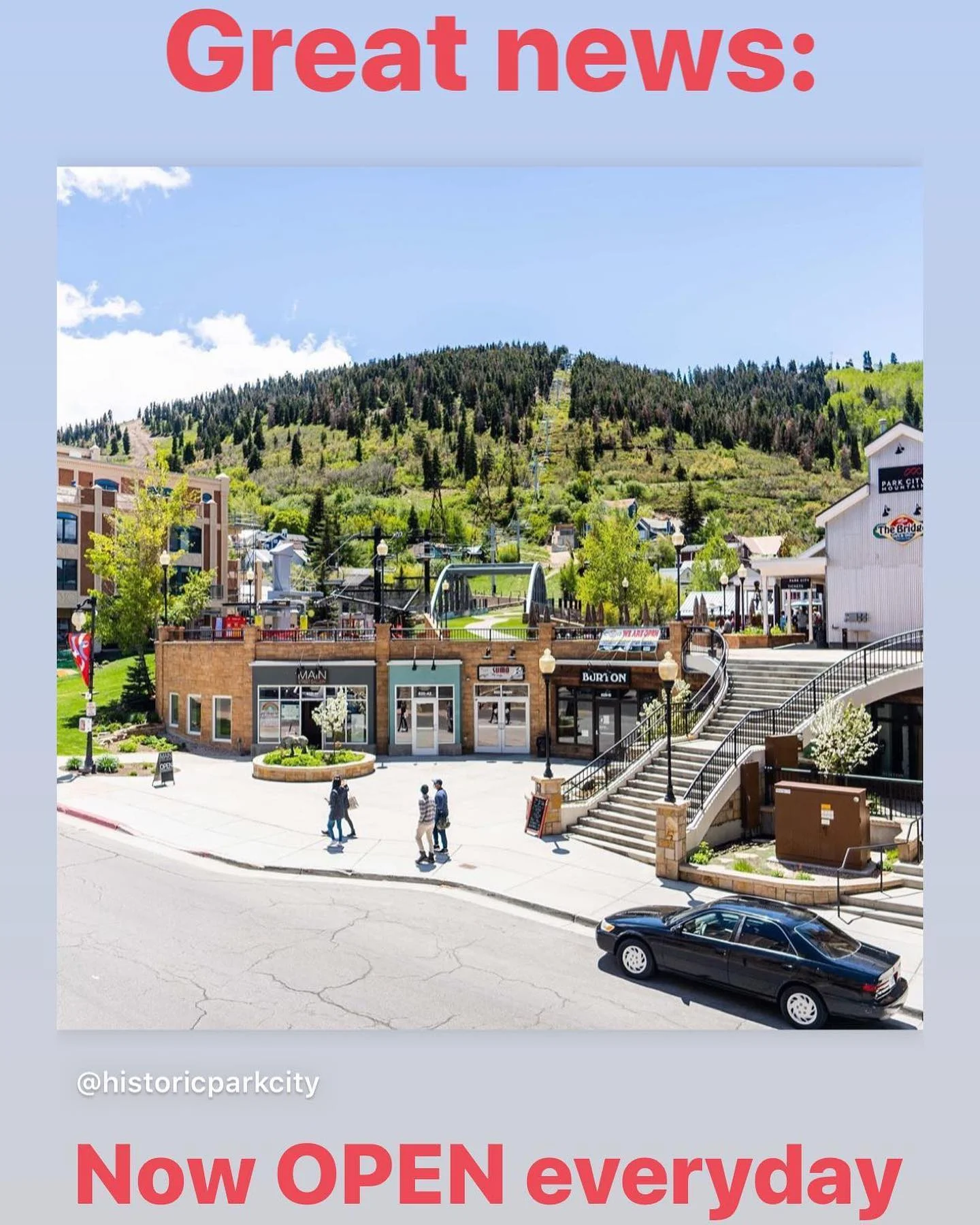 A bright sunny day in a bustling shopping district with open storefronts and visitors walking about.