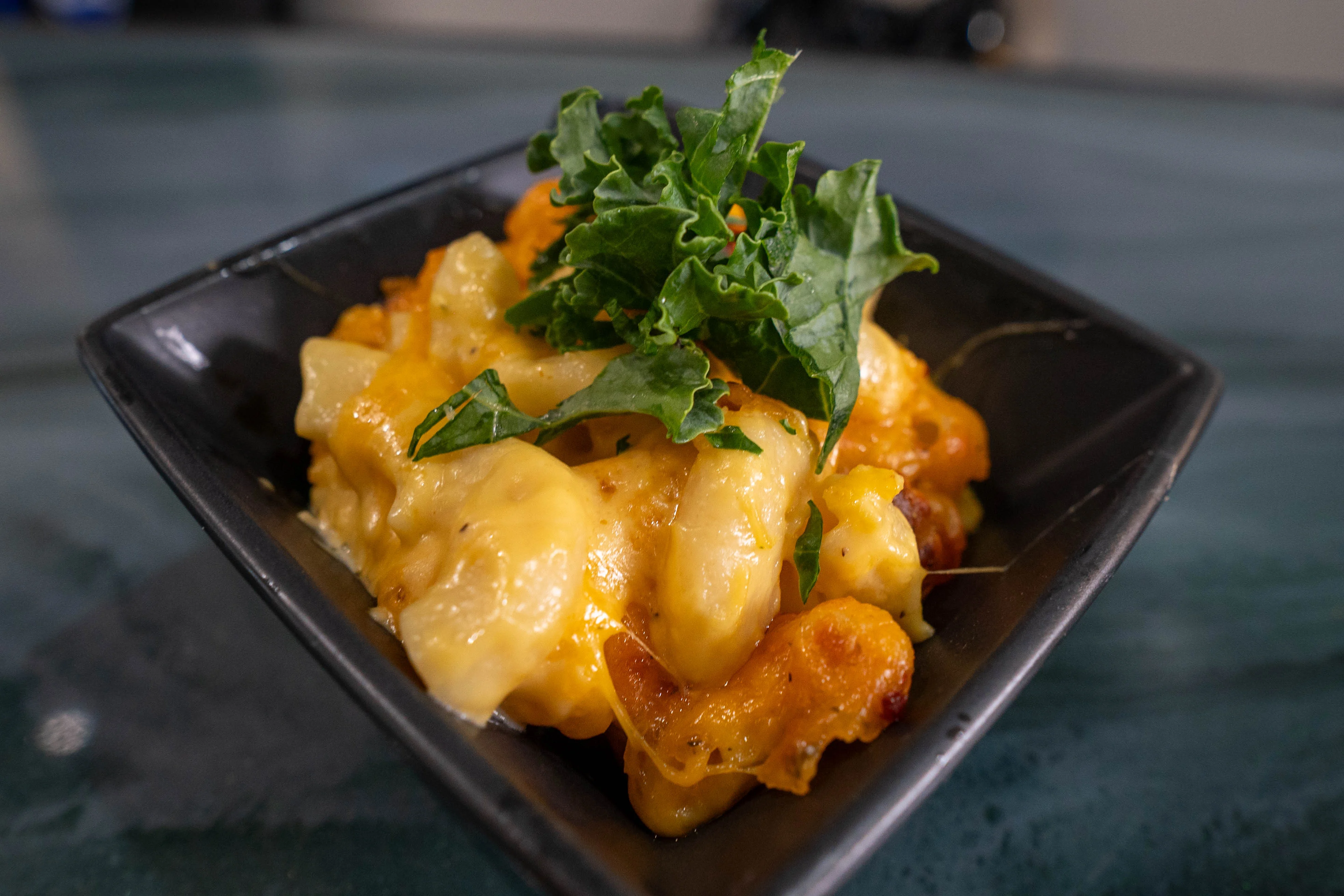 Creamy mac and cheese topped with fresh greens