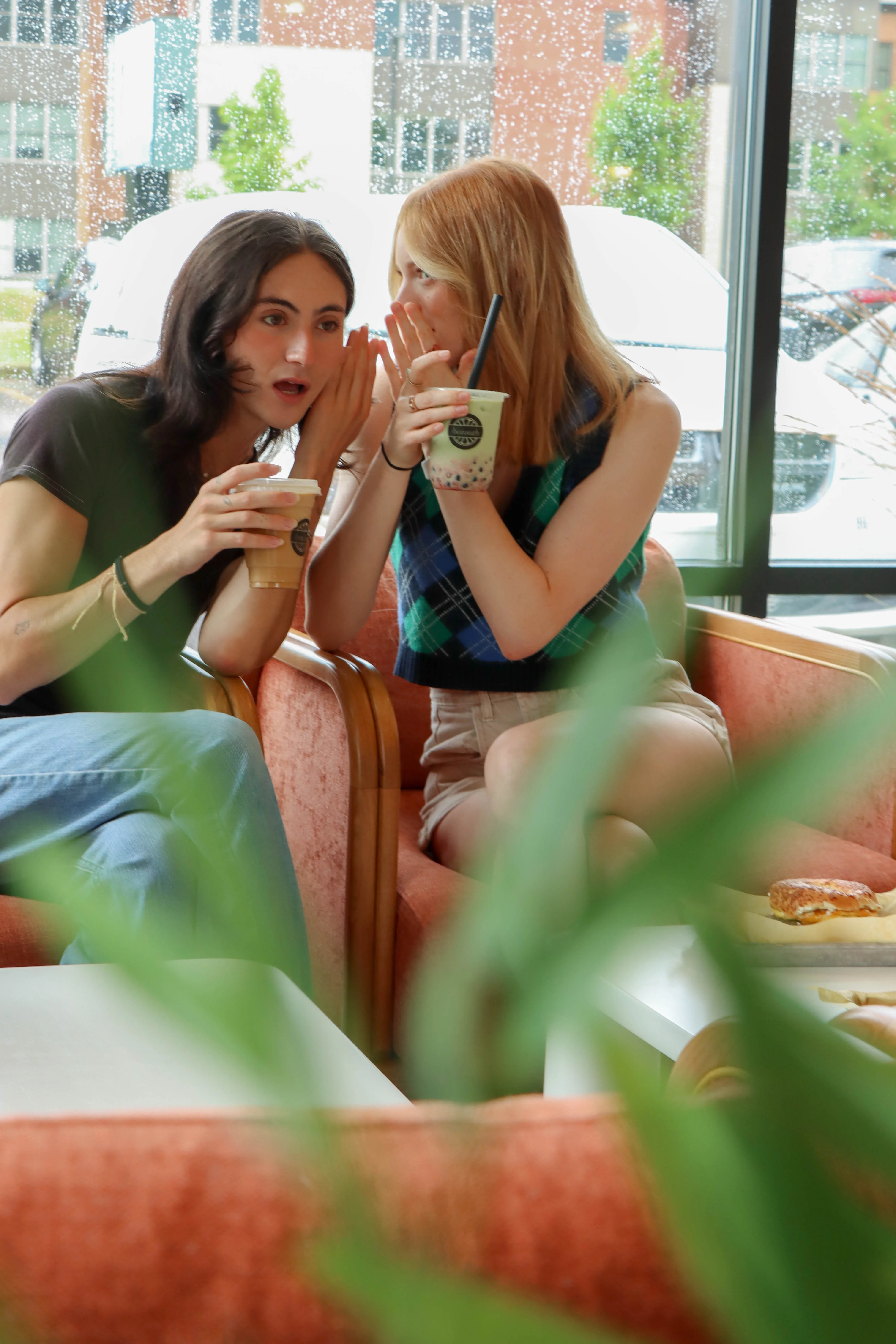 two people sitting in the borough while drinking coffee and talking
