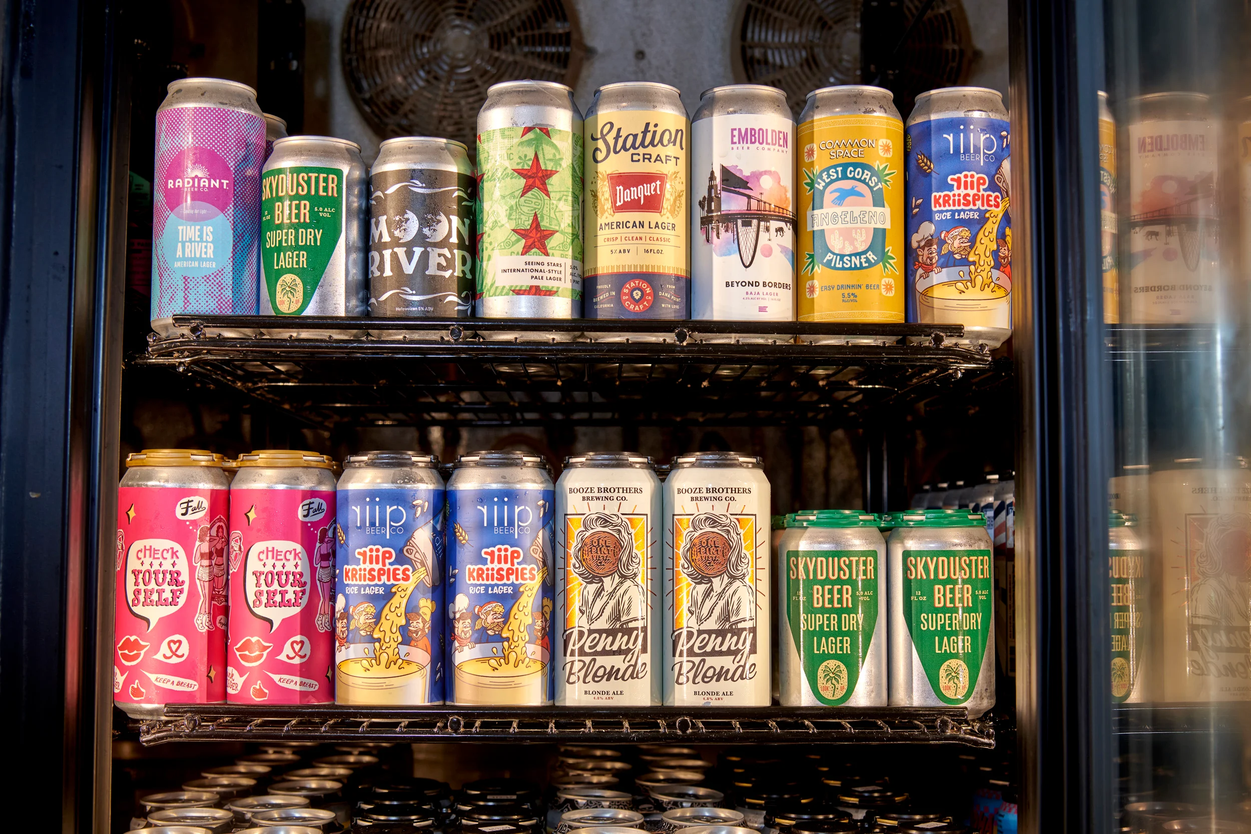 Variety of craft beer cans displayed in a cooler