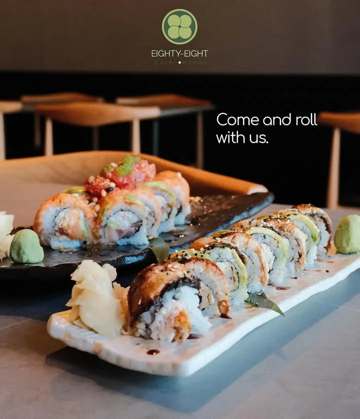 Two types of sushi rolls presented on stylish dishes, accompanied by wasabi and pickled ginger.
