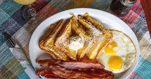 Classic American breakfast with French toast, eggs, and bacon