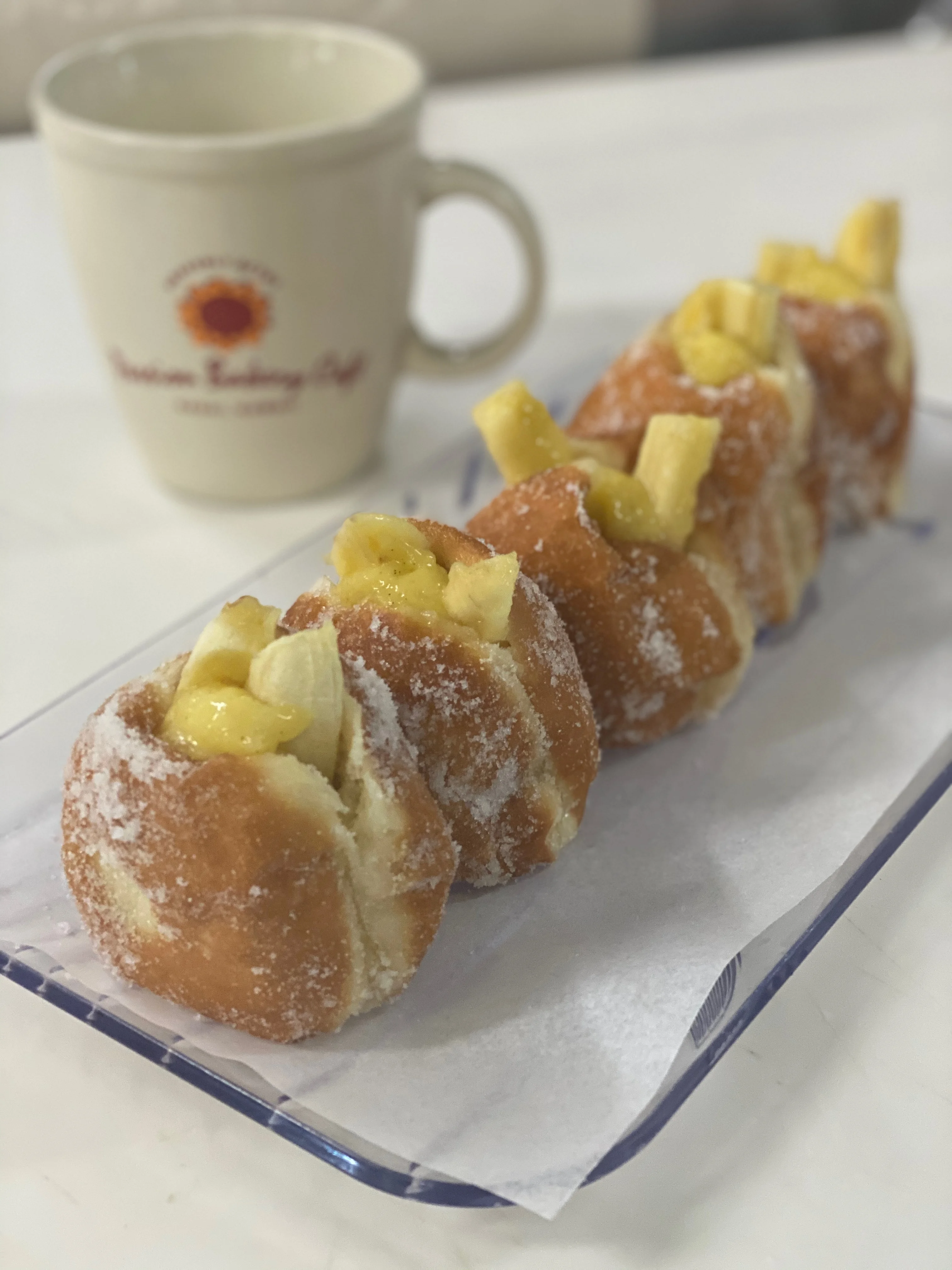 A row of malasadas and coffee