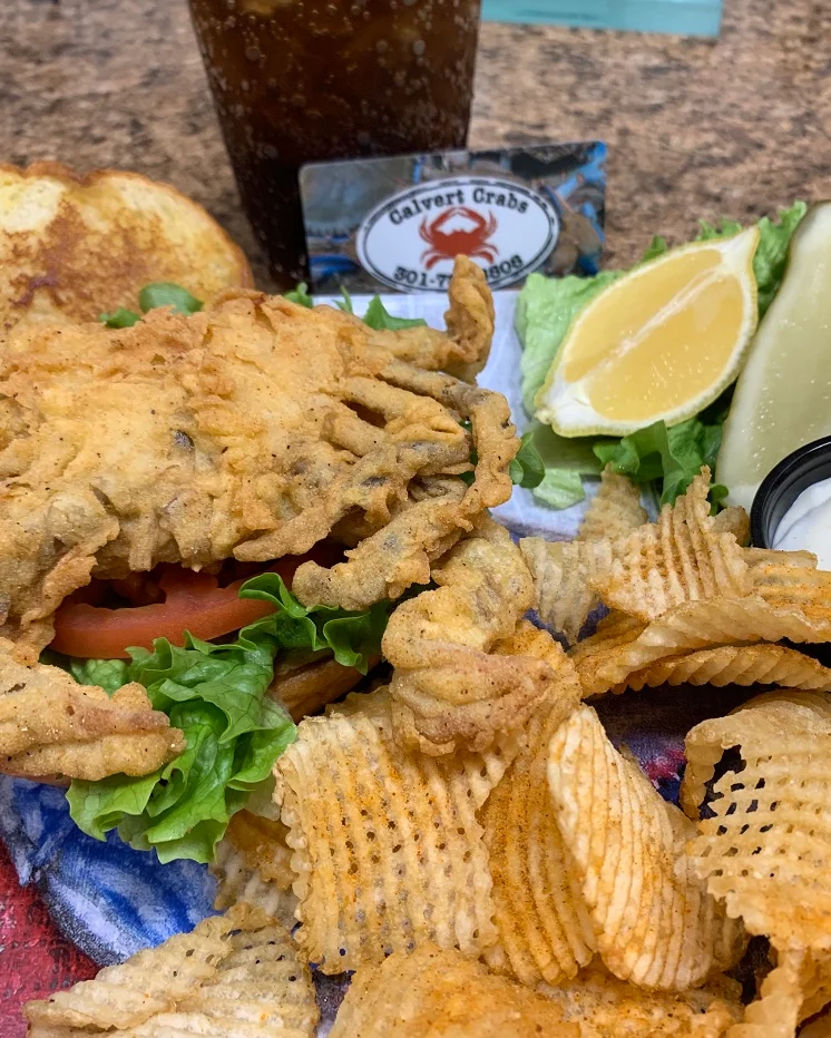 Fried soft shell crab sandwich with chips and lemon