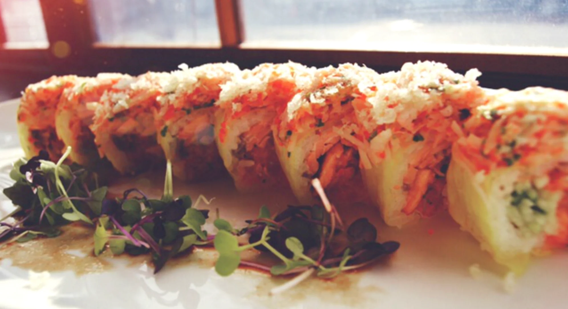 Japanese sushi rolls with crispy topping and microgreens