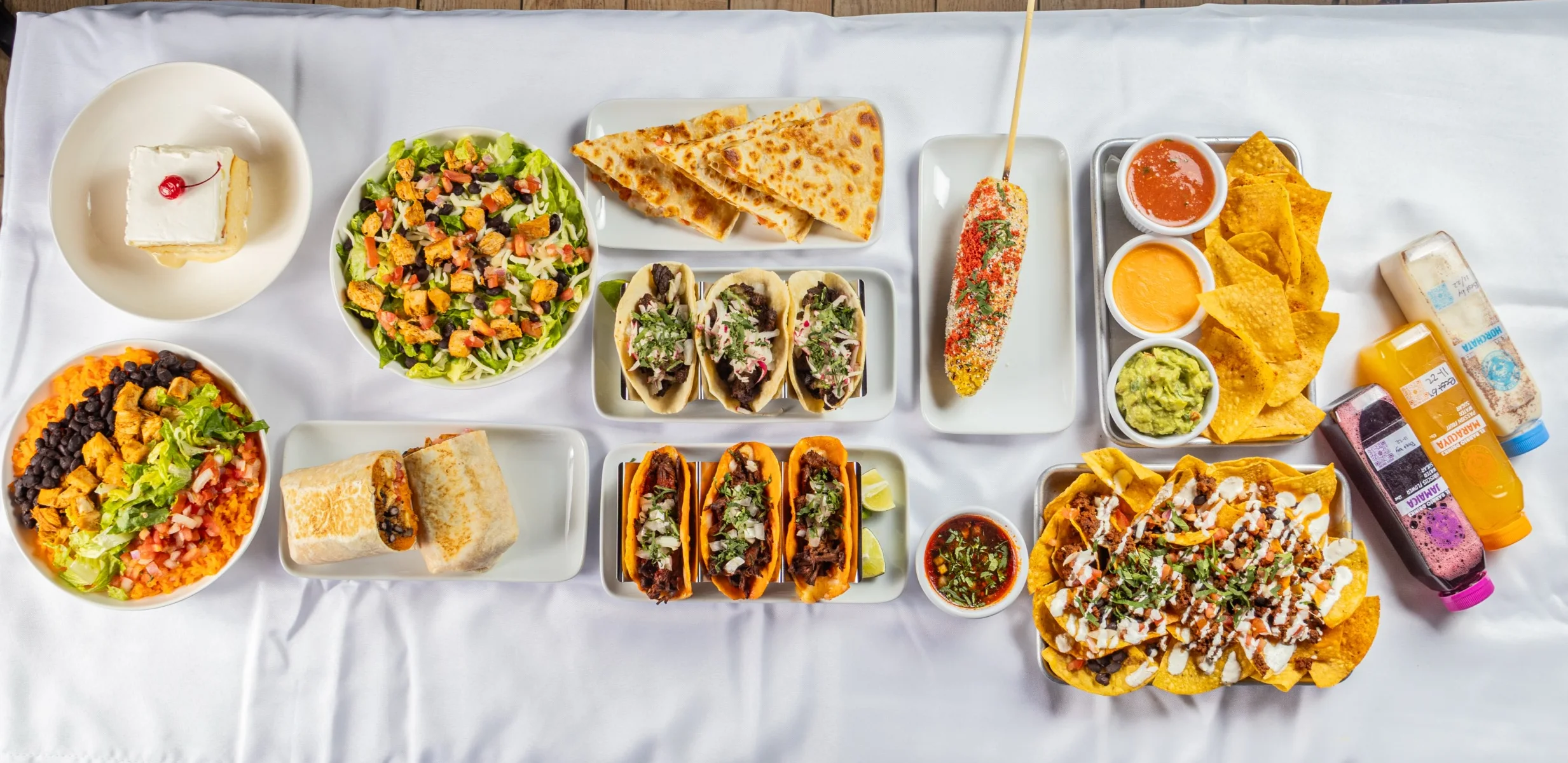 Colorful Mexican feast with tacos, nachos, and elote
