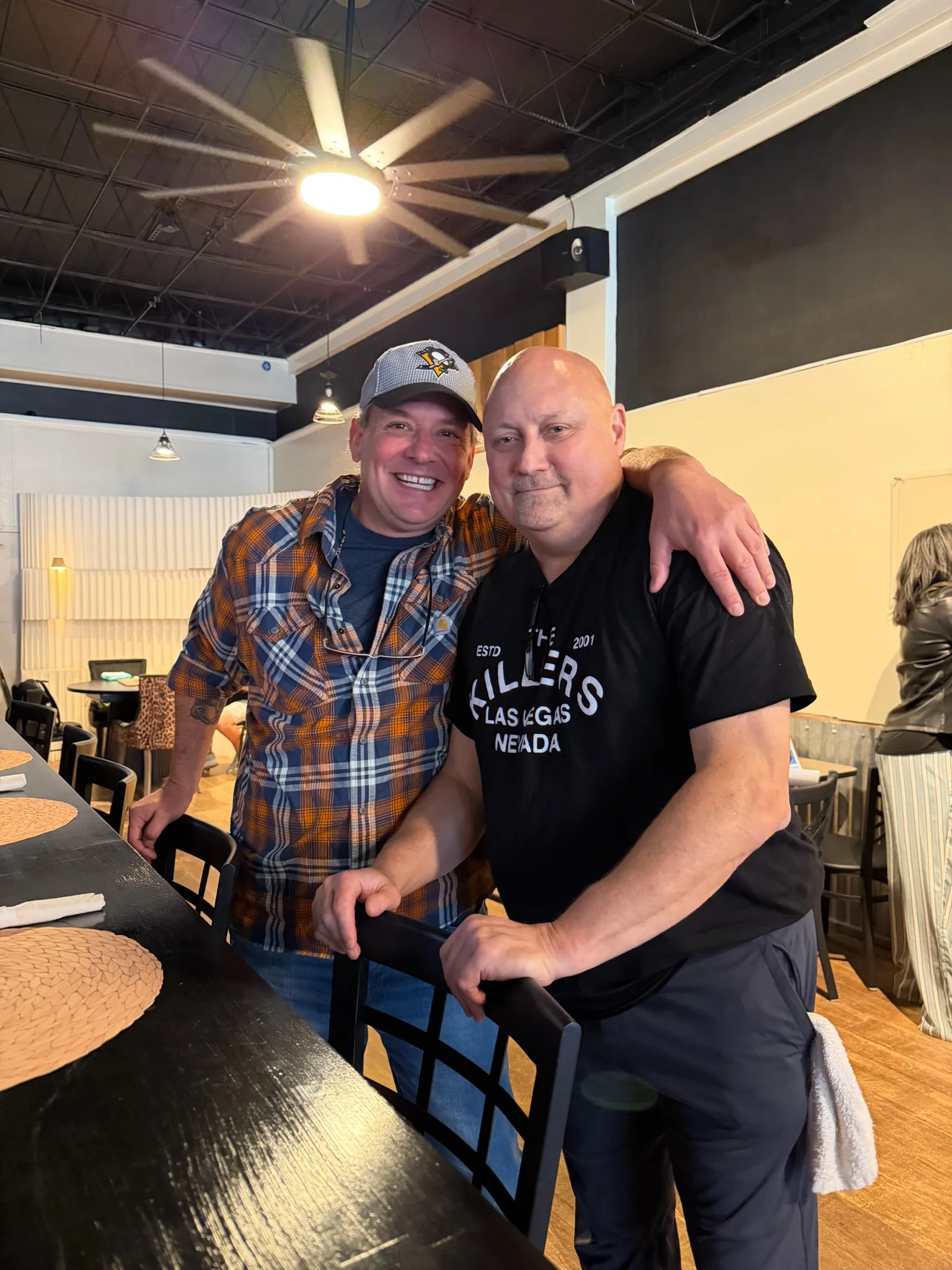 Two friends posing in a cozy restaurant interior