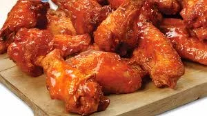 Spicy Buffalo chicken wings served on a wooden platter
