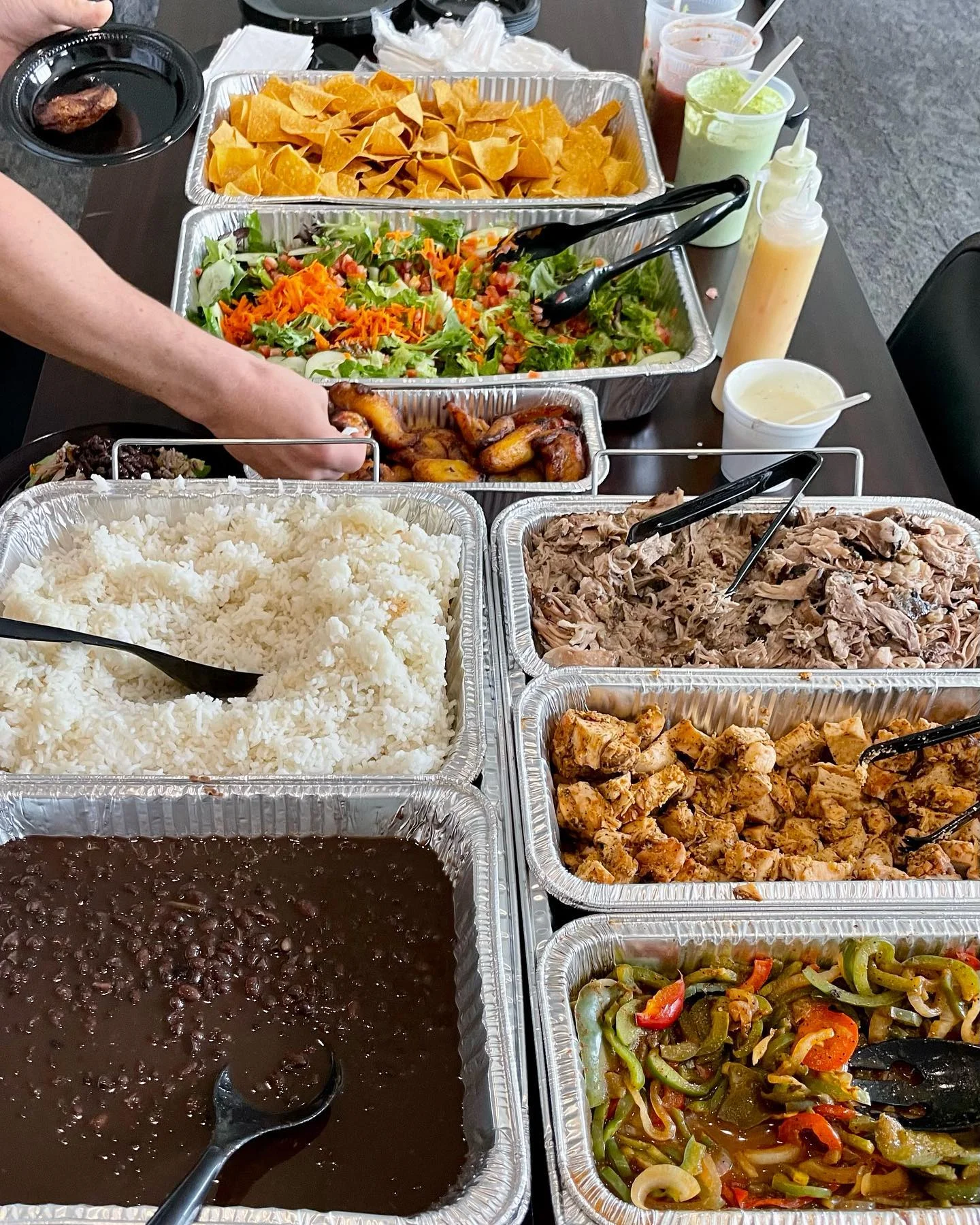 Catering spread of Mexican cuisine with rice, beans, and grilled meats