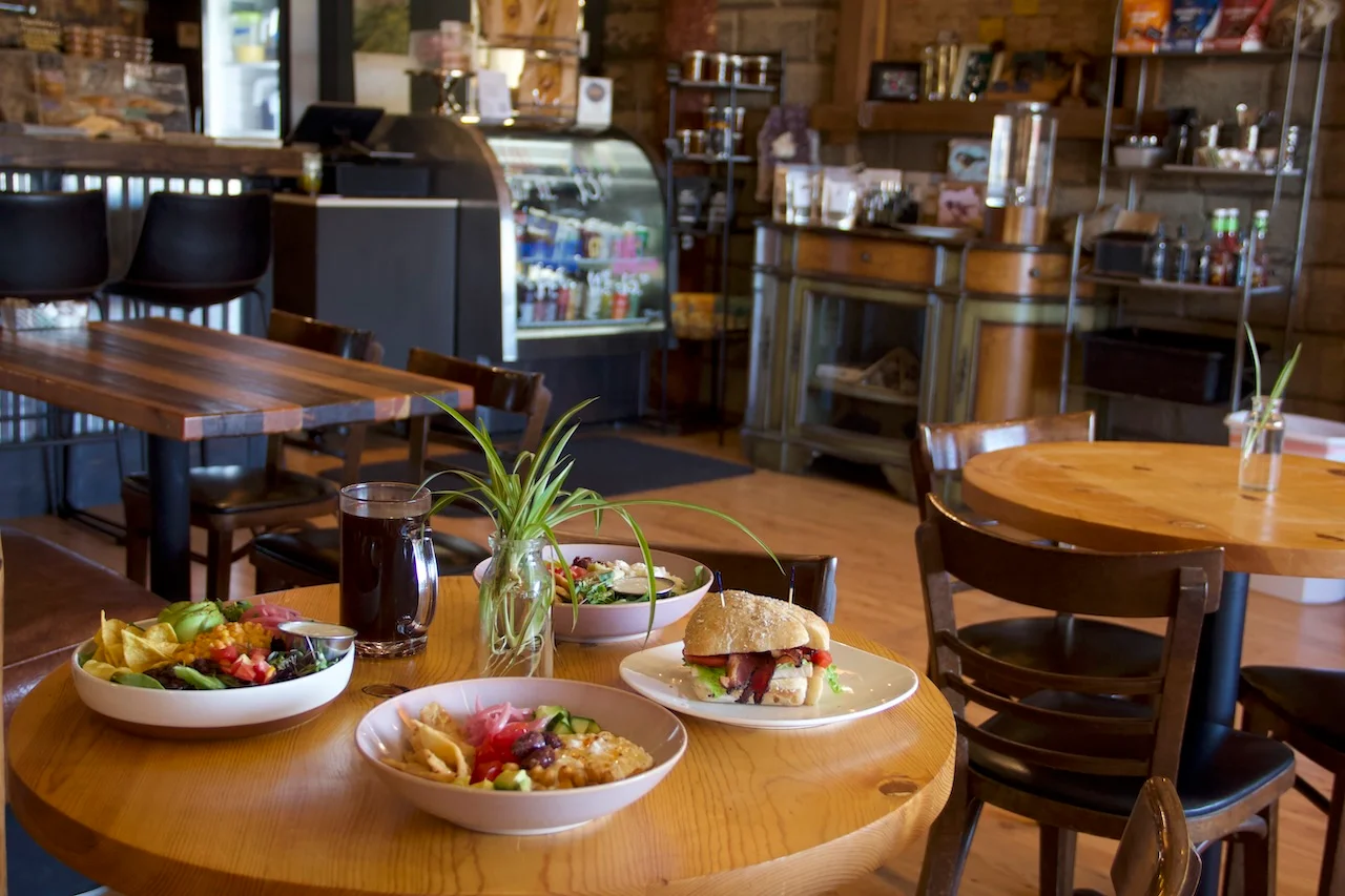 Cozy restaurant interior with diverse dishes on wooden tables