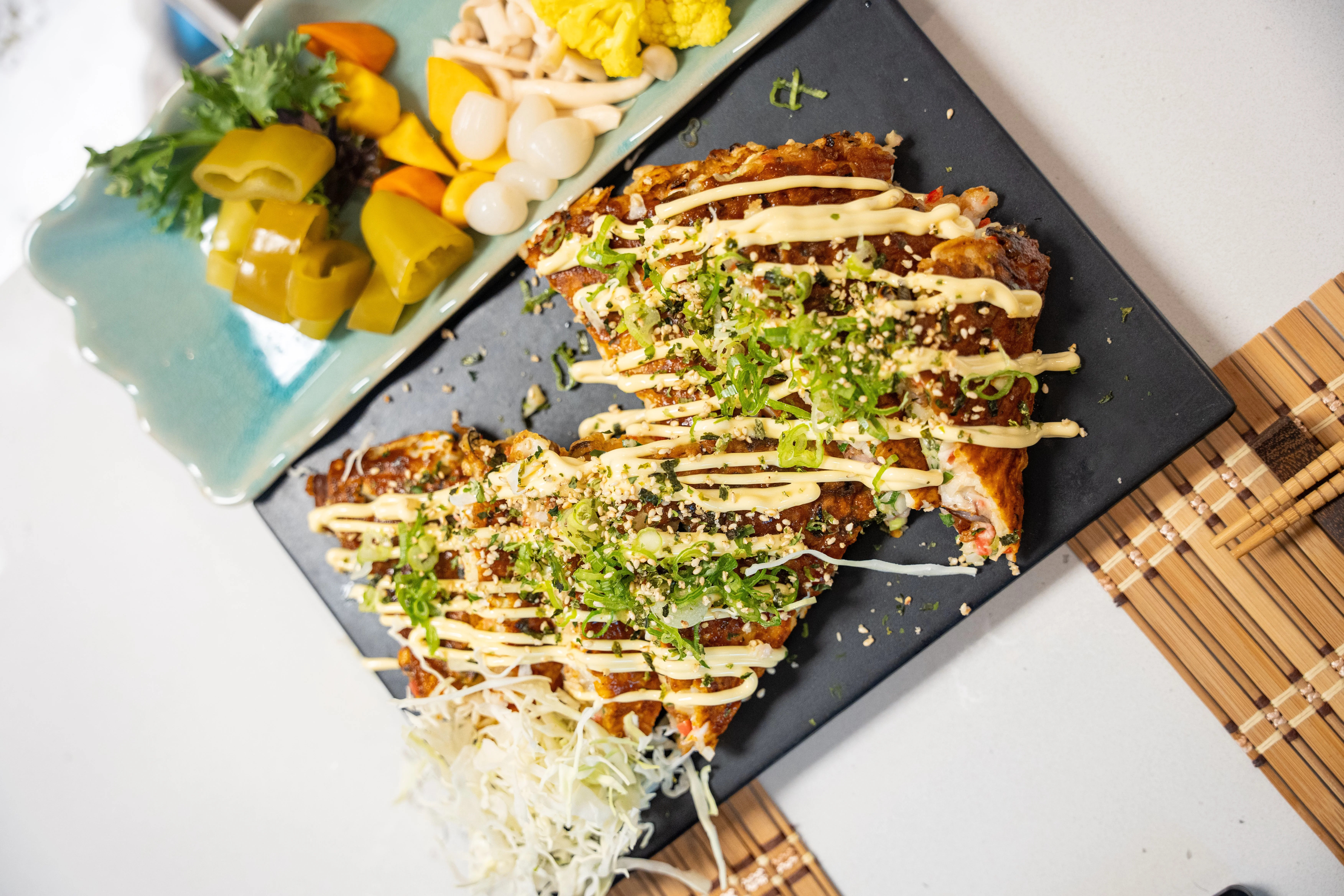 A picture of a Japanese cabbage pancake with sauce on top
