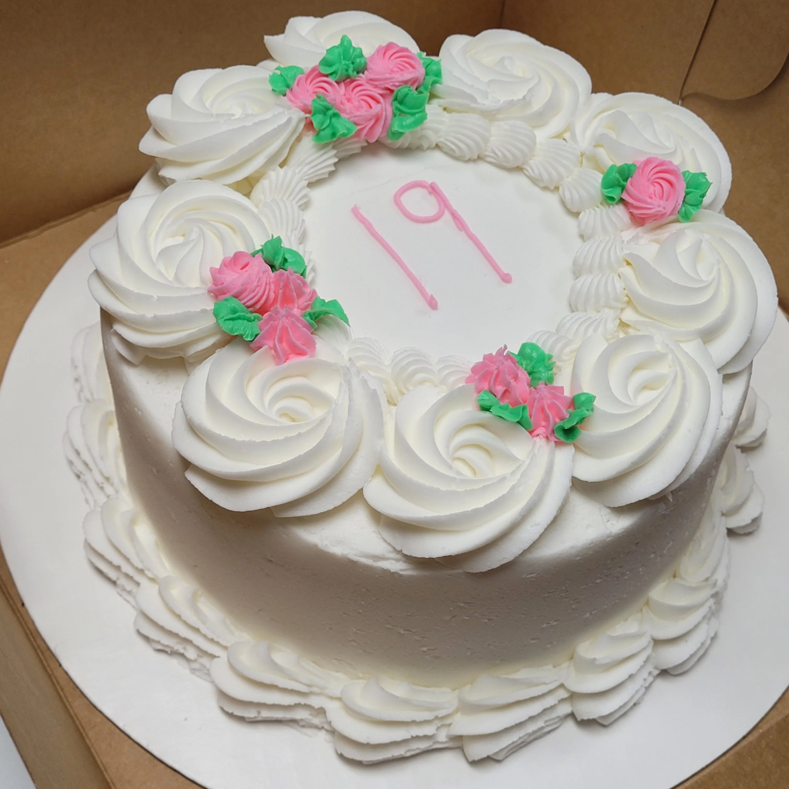 Decorative birthday cake with white frosting and floral accents