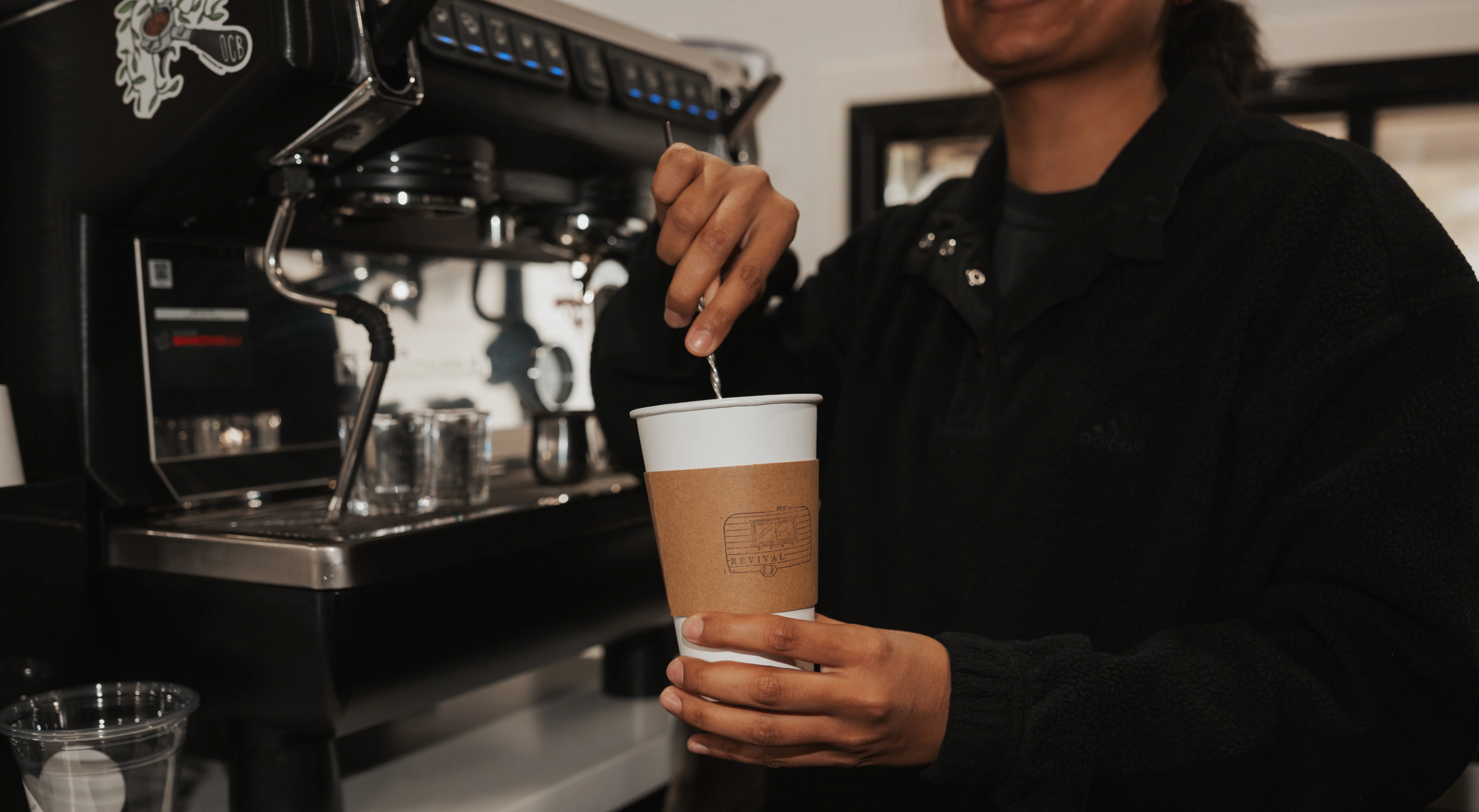 Barista stirring syrup into espresso.
