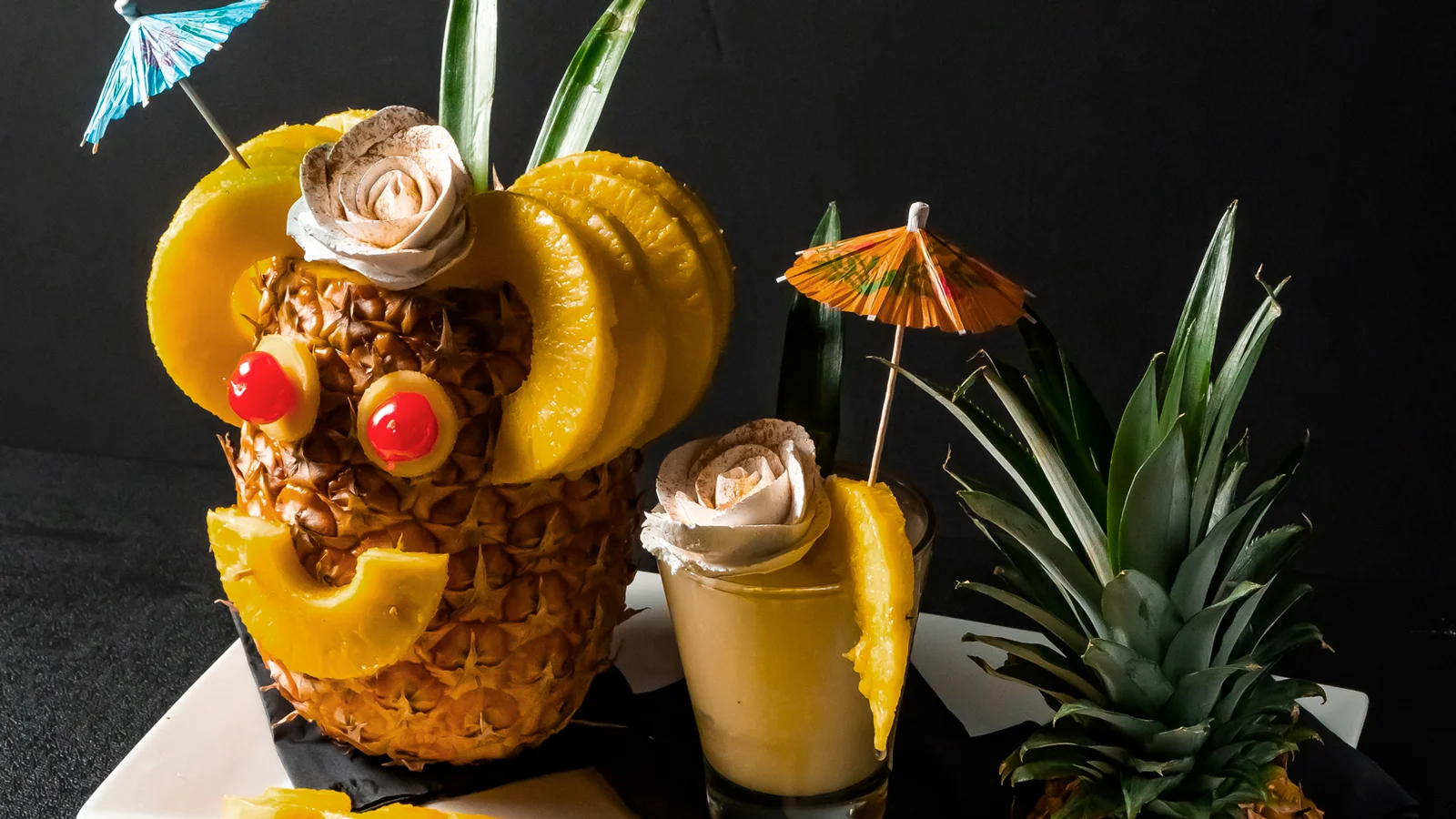 Creative tropical cocktail served in a pineapple with decorative garnishes