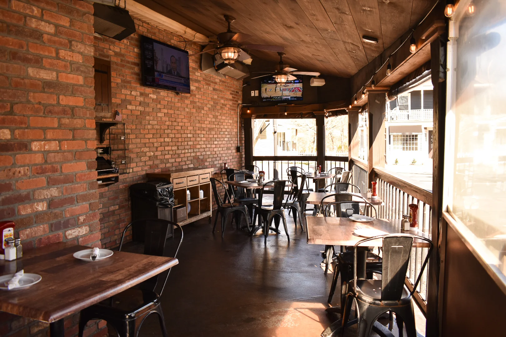 Cozy restaurant patio with brick walls and metal tables