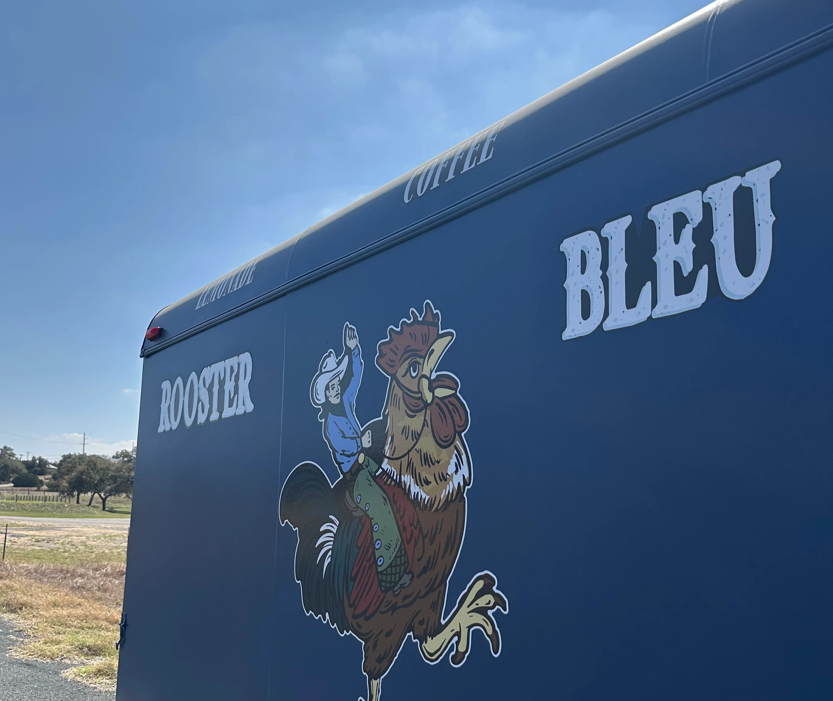Colorful food truck named Rooster Bleu with a rooster logo