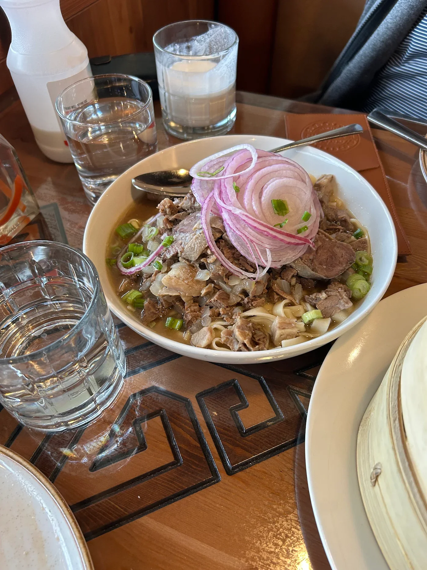 Bowl of Peruvian beef noodle soup with onions