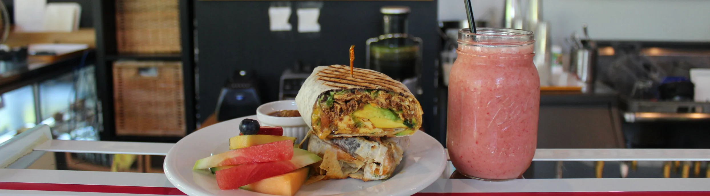 Delicious breakfast burrito with fresh fruit and smoothie