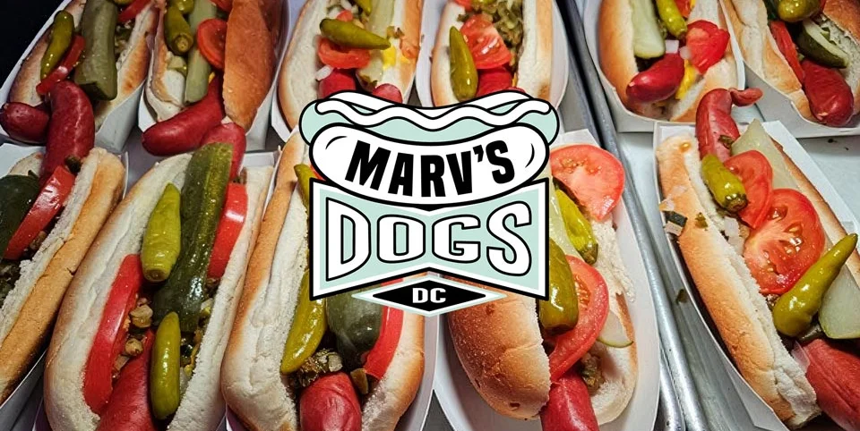 Marv's Dogs logo featuring a diamond shape and vibrant colors.