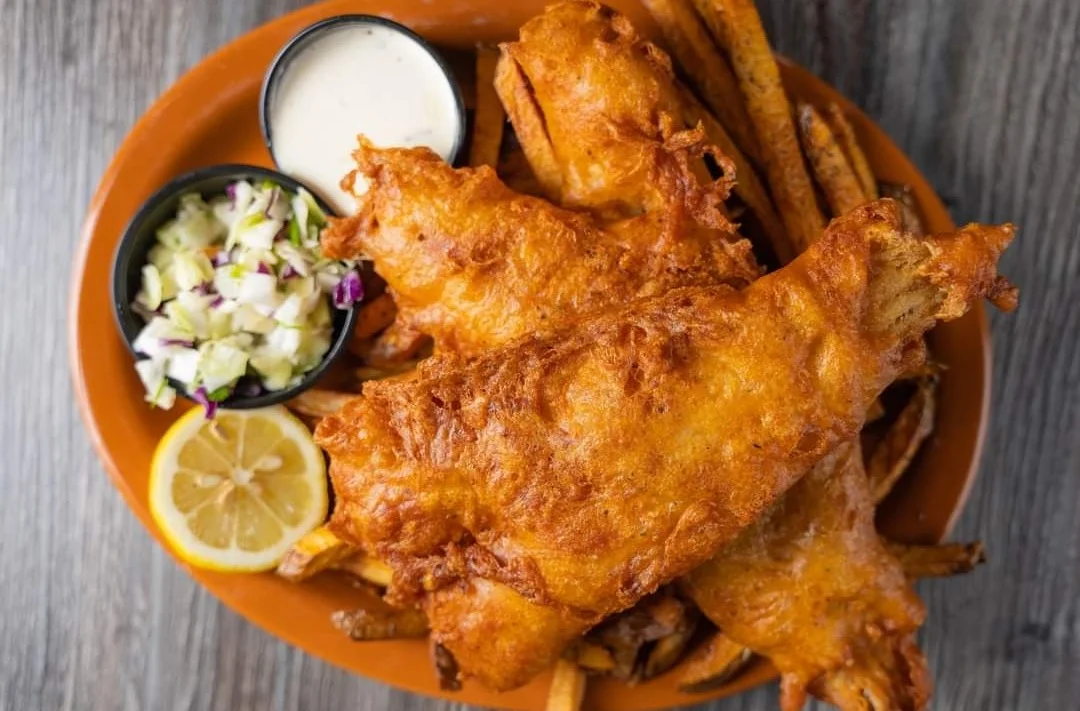 Crispy fish and chips served with coleslaw and lemon