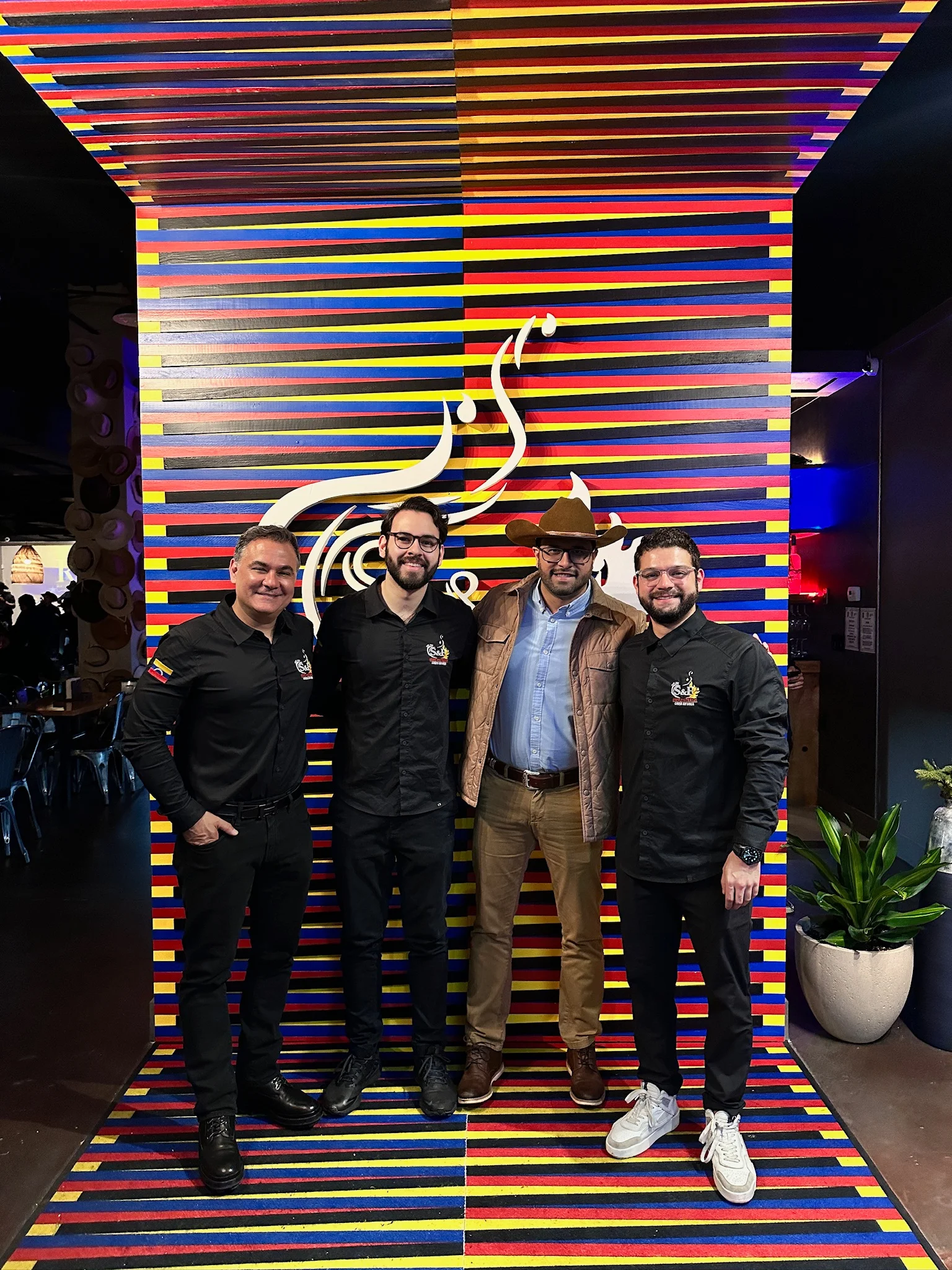 Group of restaurant staff in front of a colorful backdrop