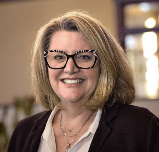 Smiling woman with glasses in a cozy restaurant setting