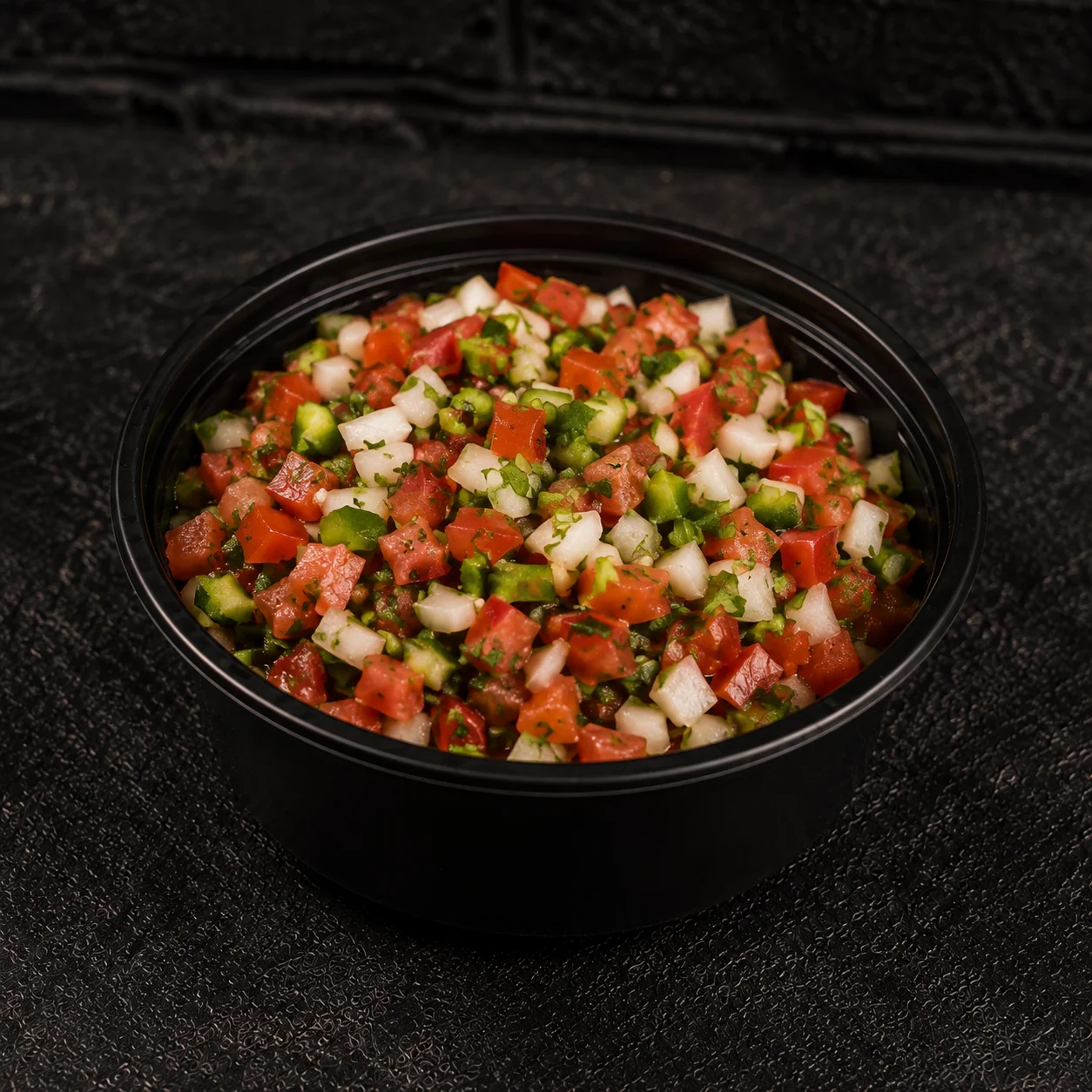Fresh Mexican pico de gallo salsa in a black bowl