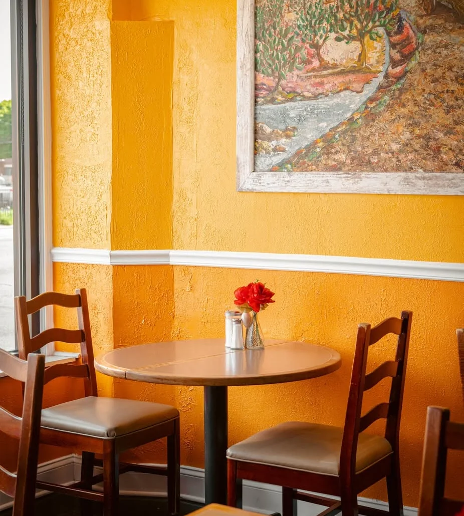 Cozy restaurant interior with vibrant orange walls and artwork