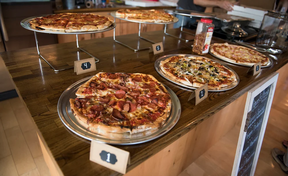Variety of pizzas displayed in a cozy restaurant setting