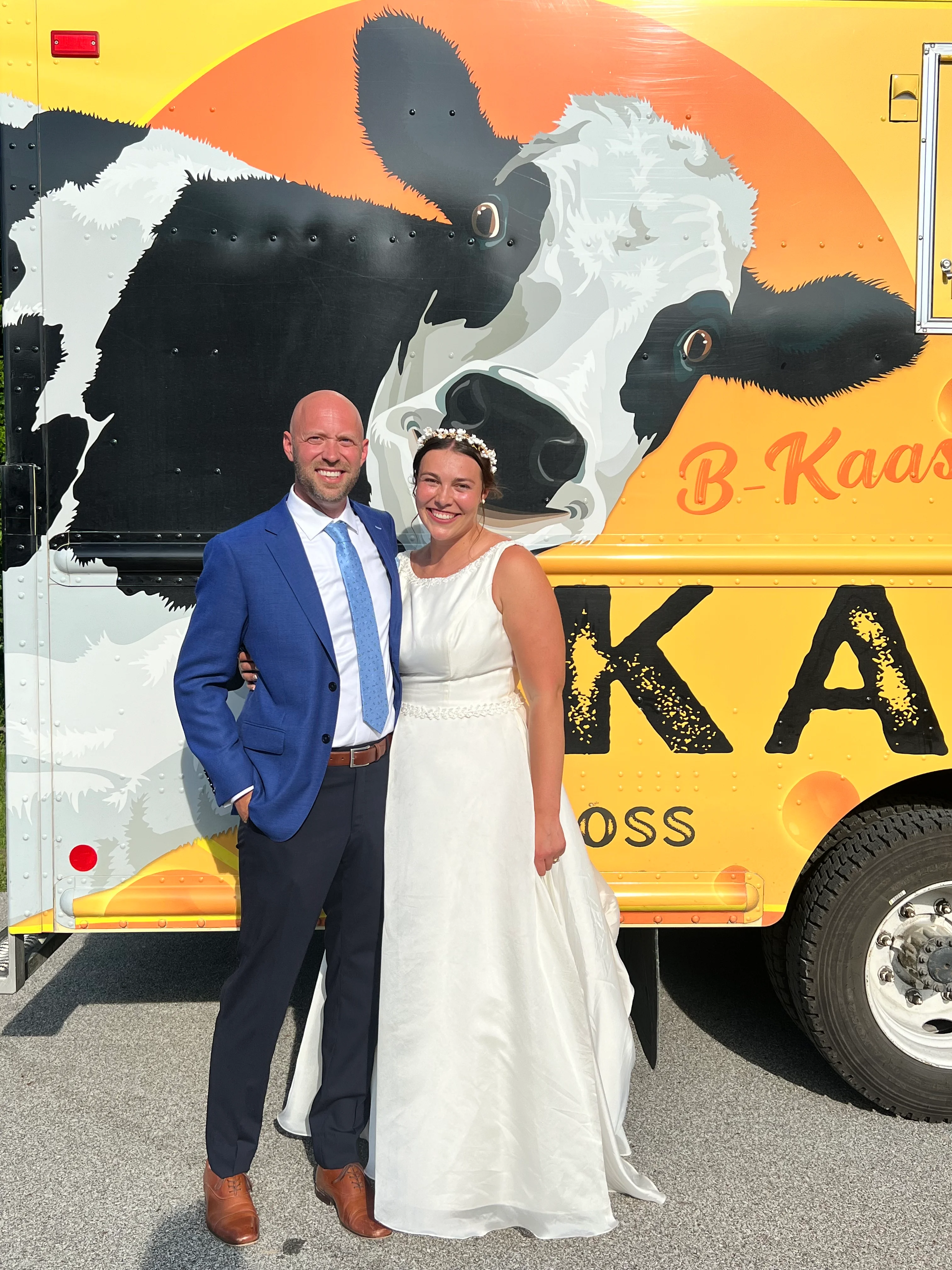 Couple posing in front of a food truck with a cow mural