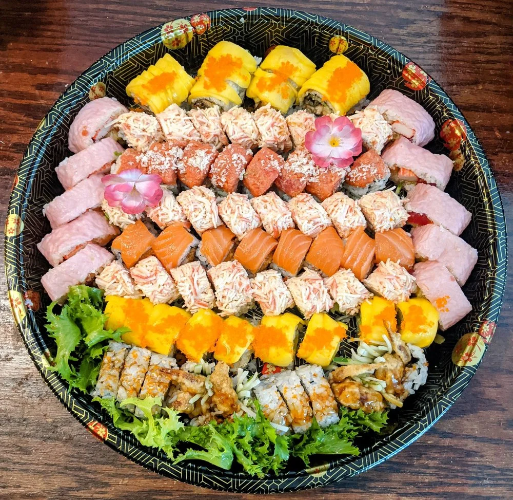 Assorted sushi platter featuring colorful rolls and garnishes